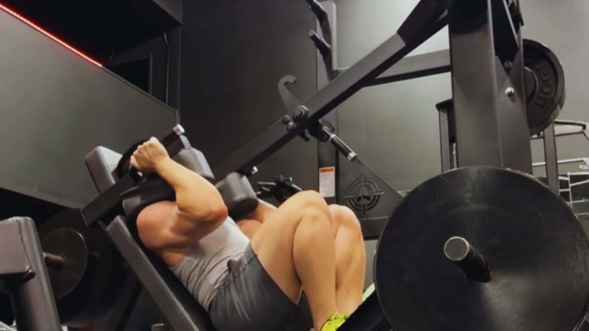 2. In a gym setting, a man is engaged in a bench press, lifting a barbell while lying on a bench.