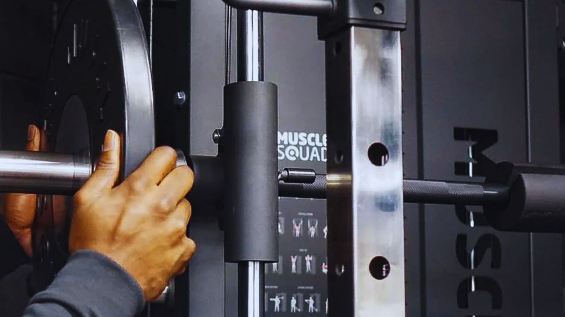 A person performs squats on a squat machine in a gym, focusing on strength training and fitness.