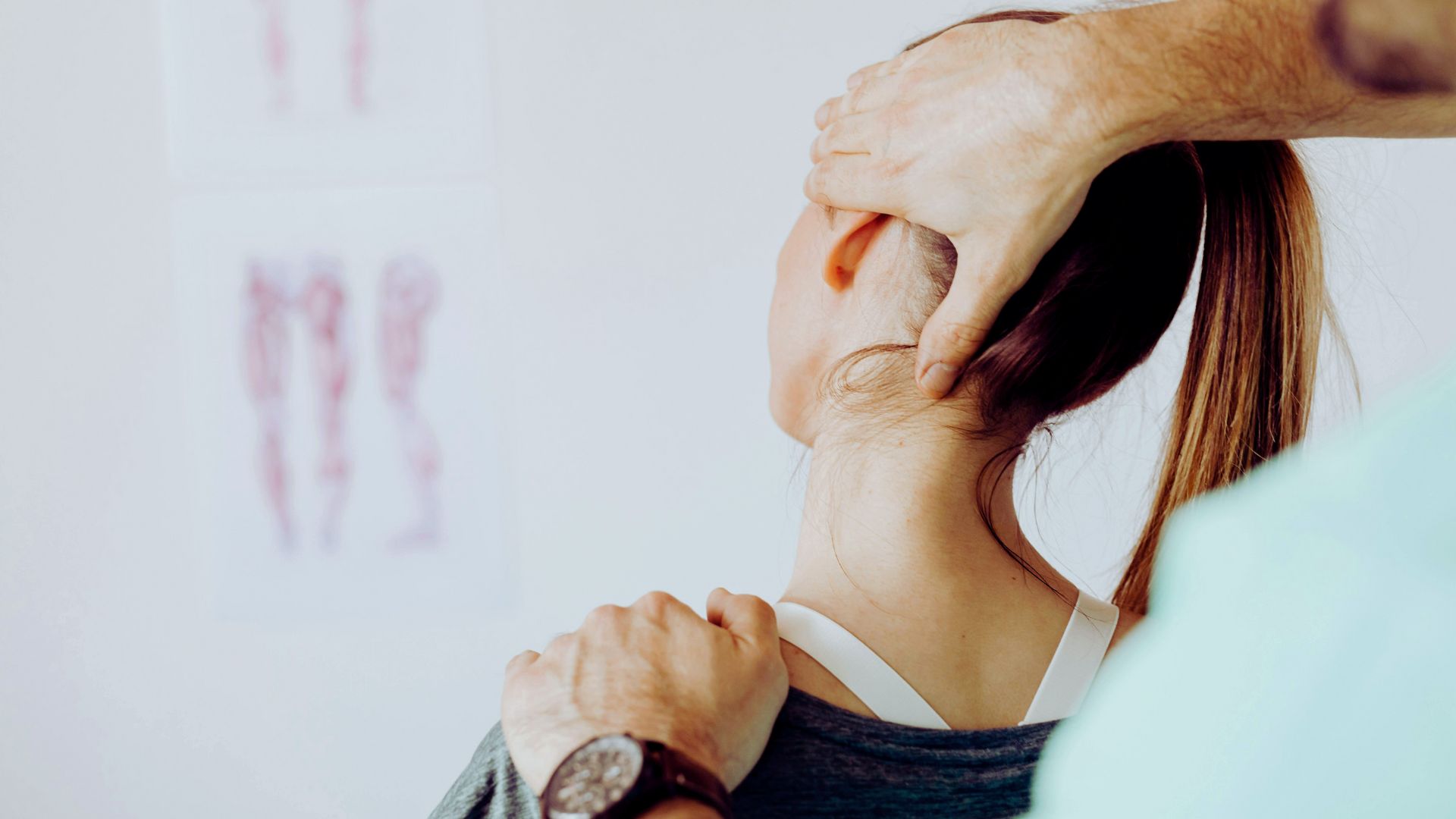 A woman receiving a chiropractic adjustment on a treatment table, with a chiropractor assisting her.