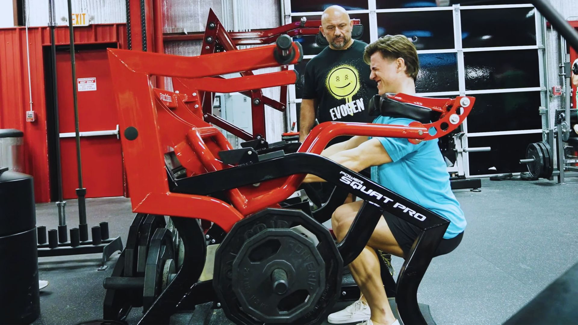 A man is engaged in a workout on a gym machine, demonstrating physical fitness in a modern gym environment