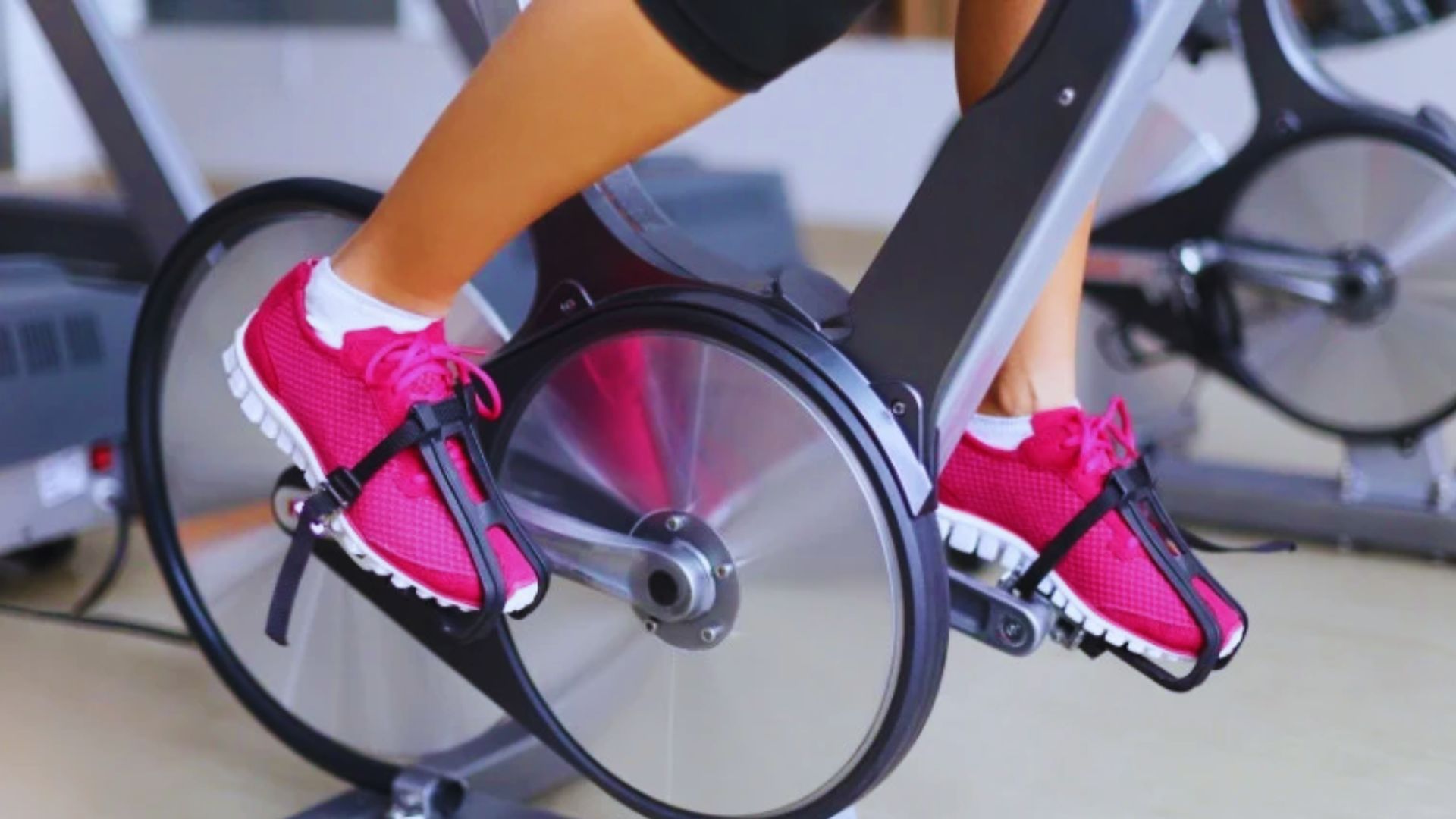 A person engaged in cycling on an exercise bike, emphasizing fitness and health.