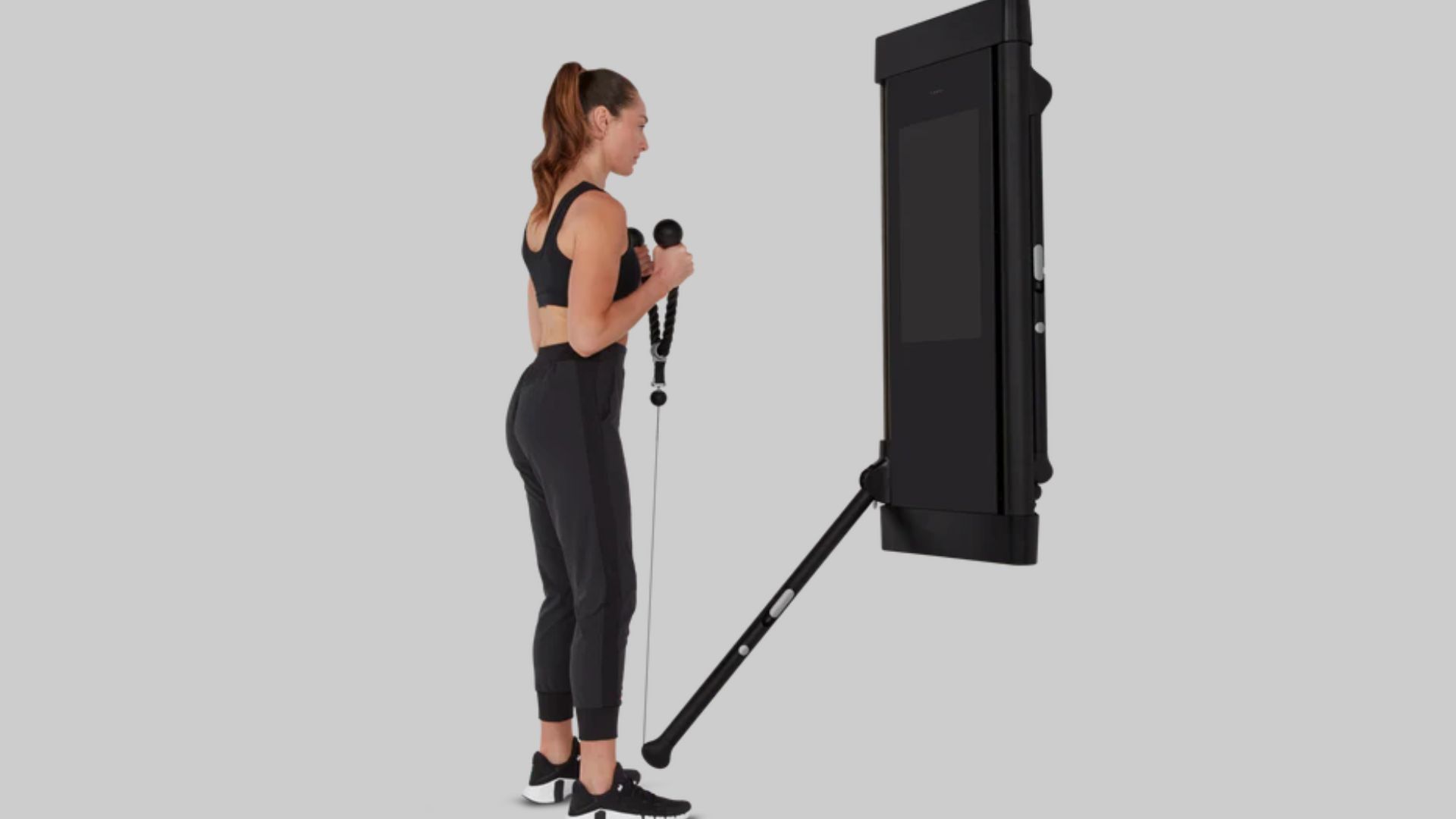 A woman stands next to a large screen featuring the phrase "Set Your Grip.