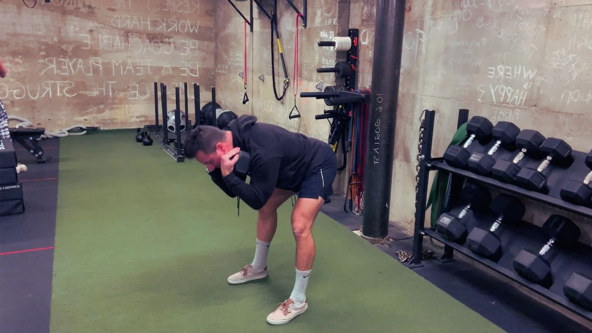 A man performing a squat in a gym, focusing on strength training with weights