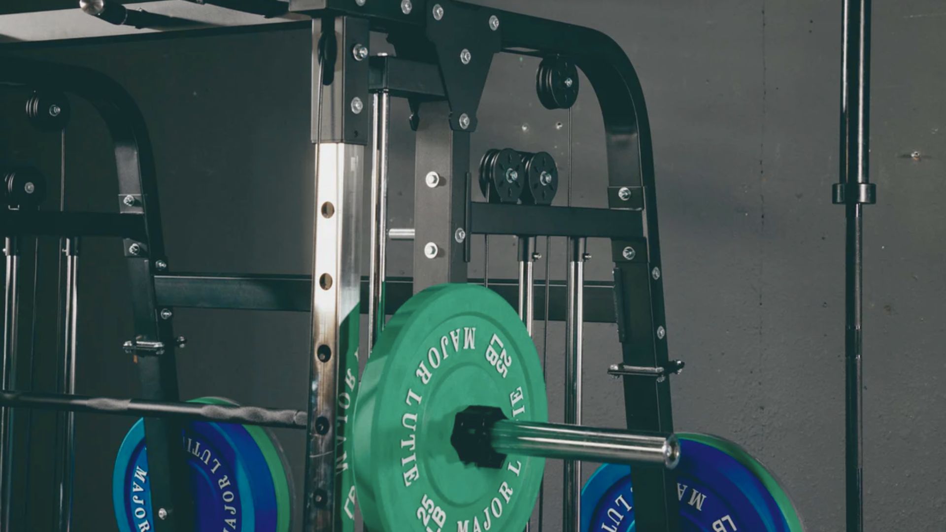 A gym rack featuring two green weight plates positioned side by side for easy access.