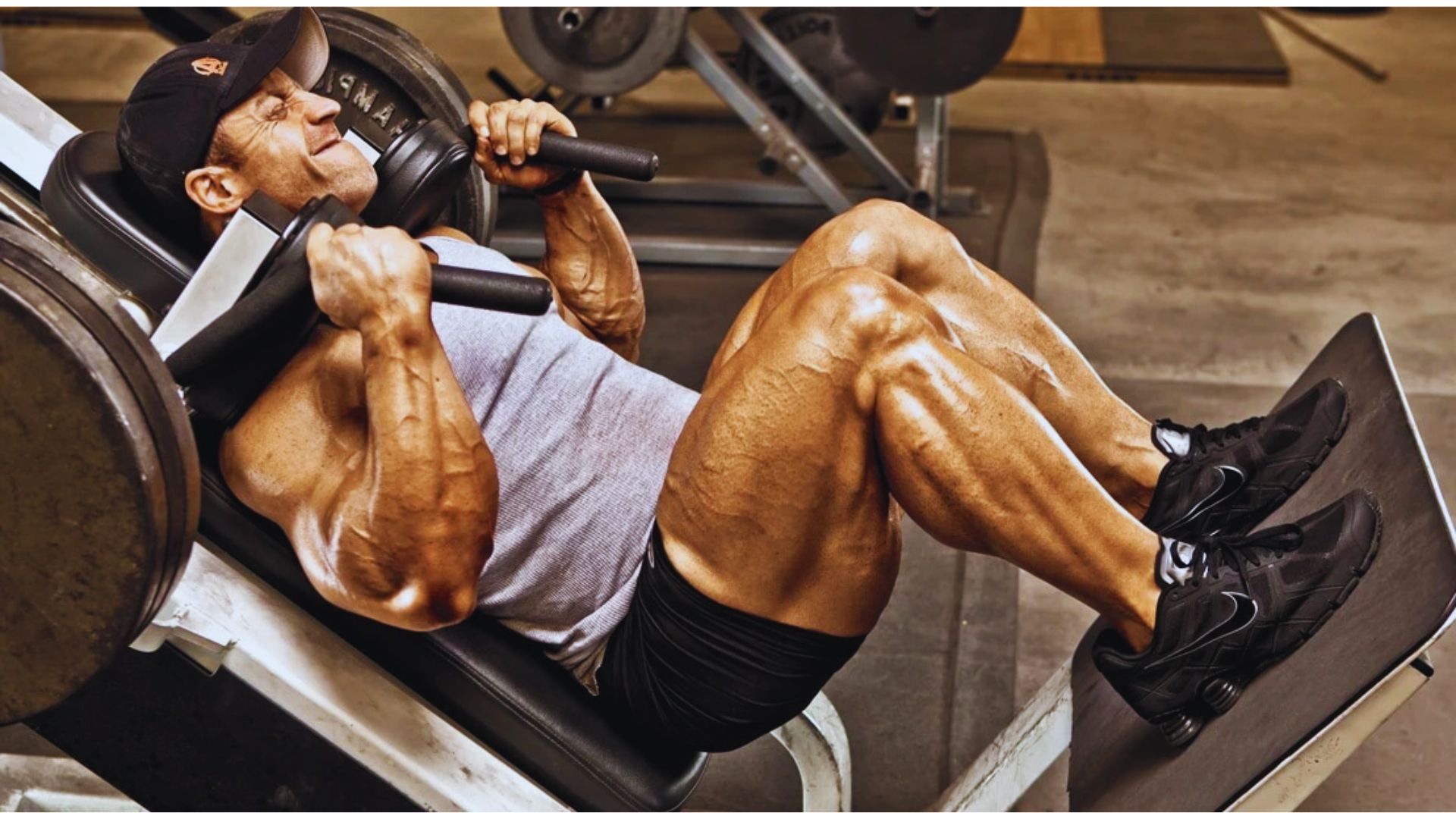 A man performs a bench press exercise in a gym, focusing on lifting a barbell above his chest.
