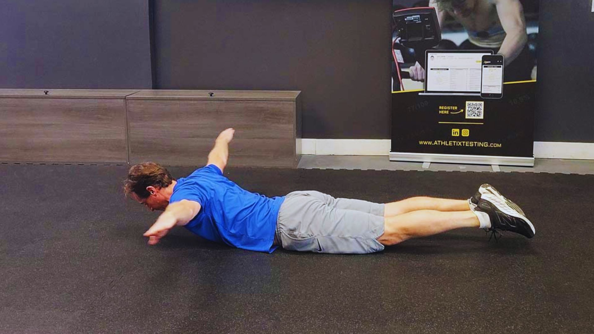 A man executing Reverse Snow Angels on a yoga mat, aimed at promoting better posture and spinal alignment.