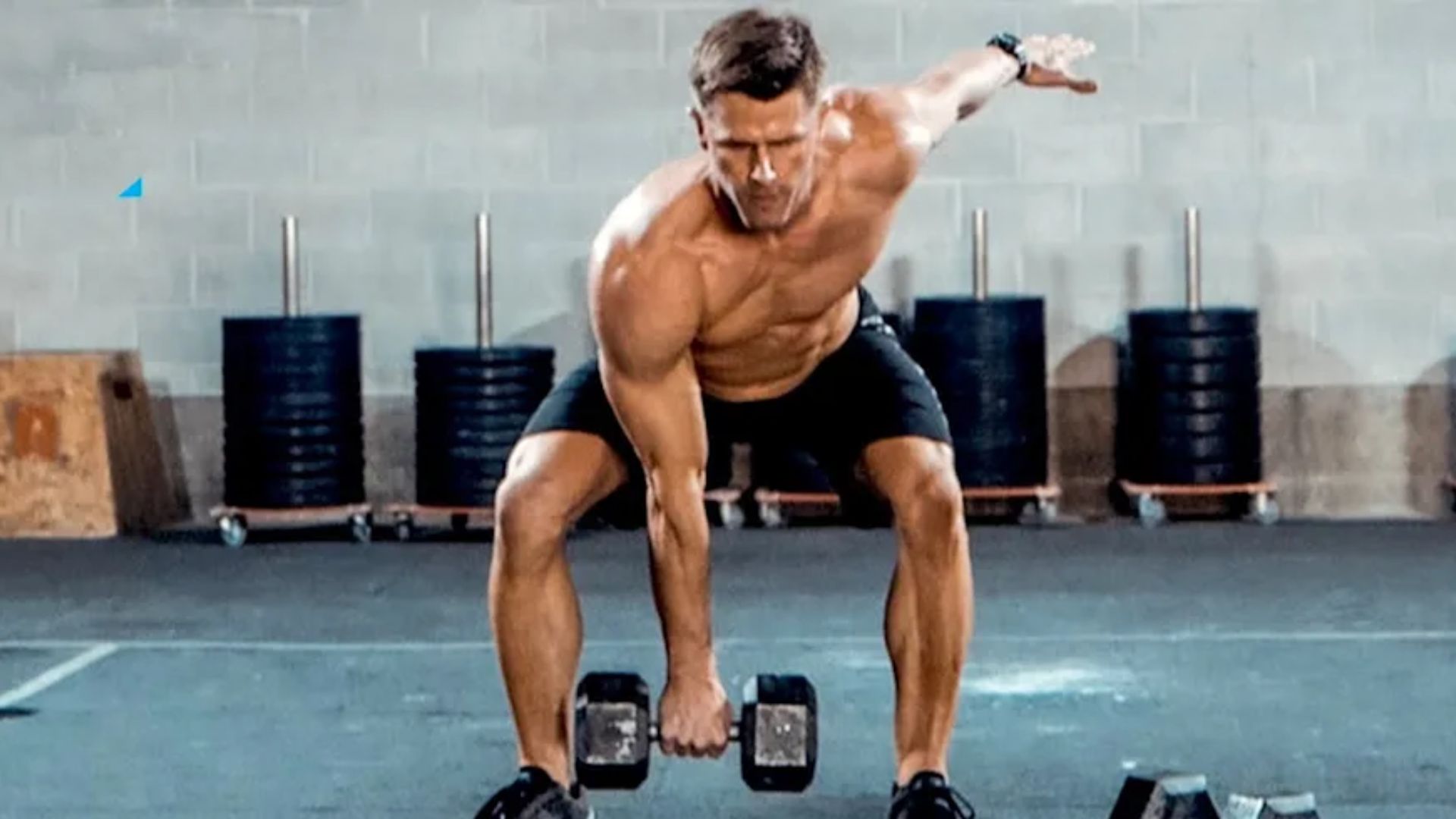 A shirtless man performs a dumbbell exercise, showcasing effective cardio with weights for strength and endurance.