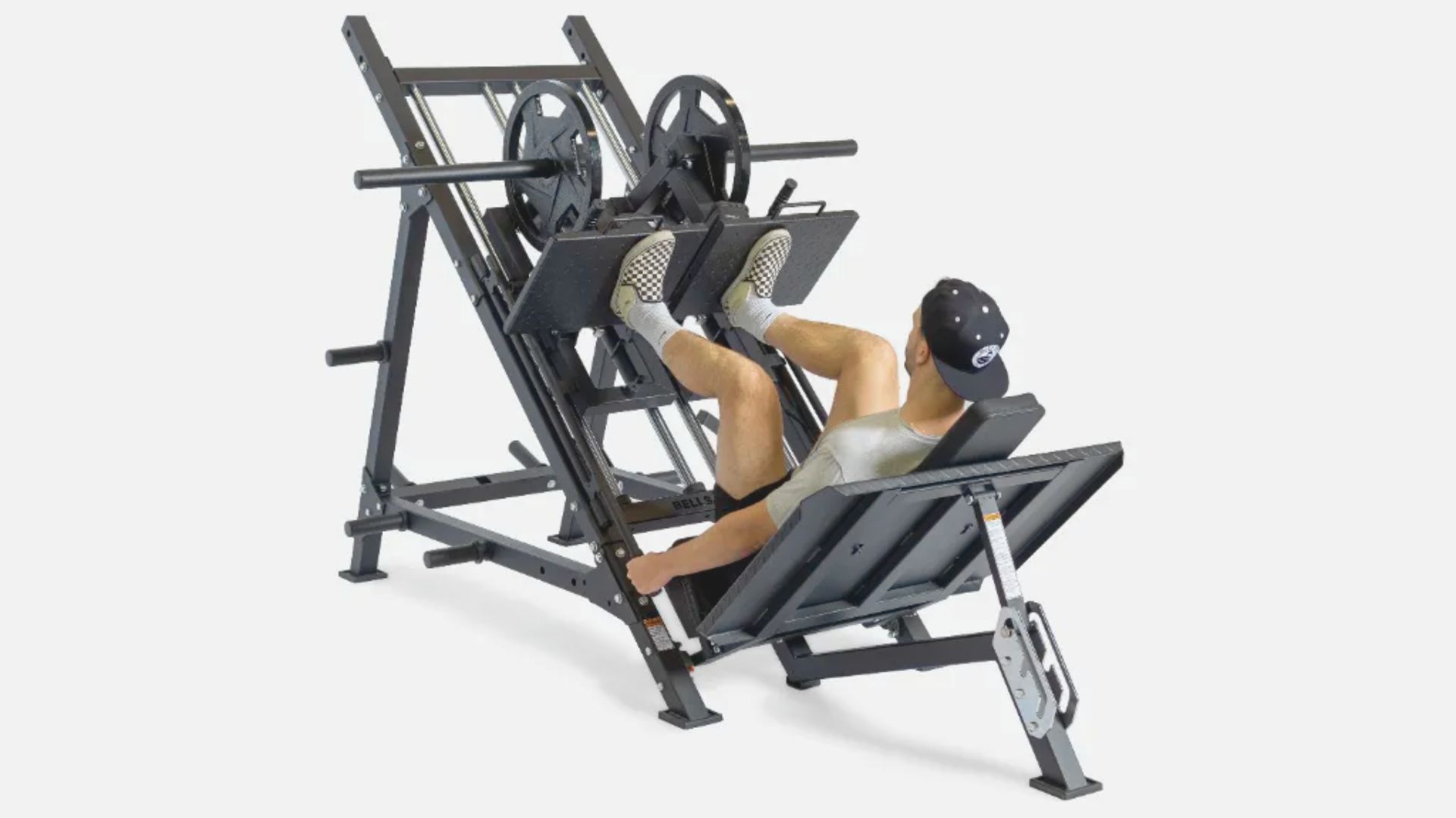 A man exercises on a leg press machine, focusing on his workout in a gym setting.