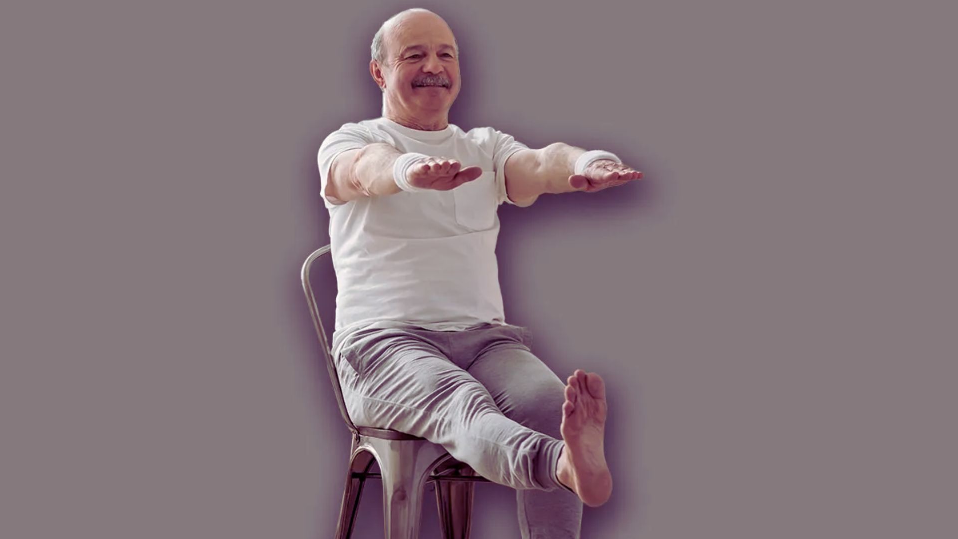 A man sitting on a chair with his hands raised, expressing excitement or surprise.