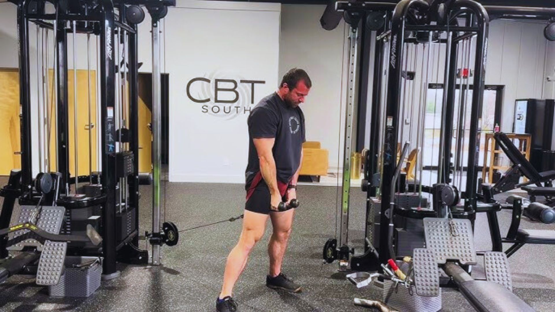 A man executing a squat in a gym, demonstrating proper form and technique for fitness training.
