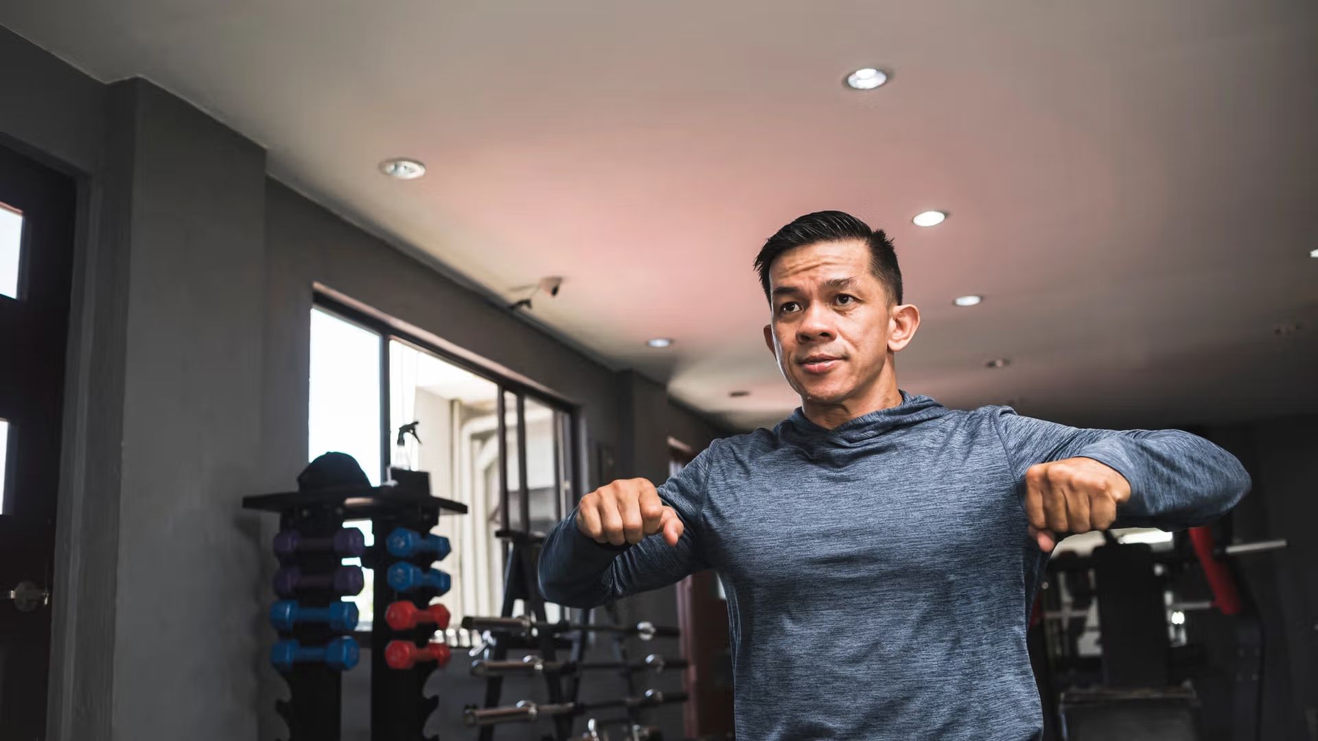 A man performs a chest workout in a gym, focusing on stretching and strengthening his muscles.