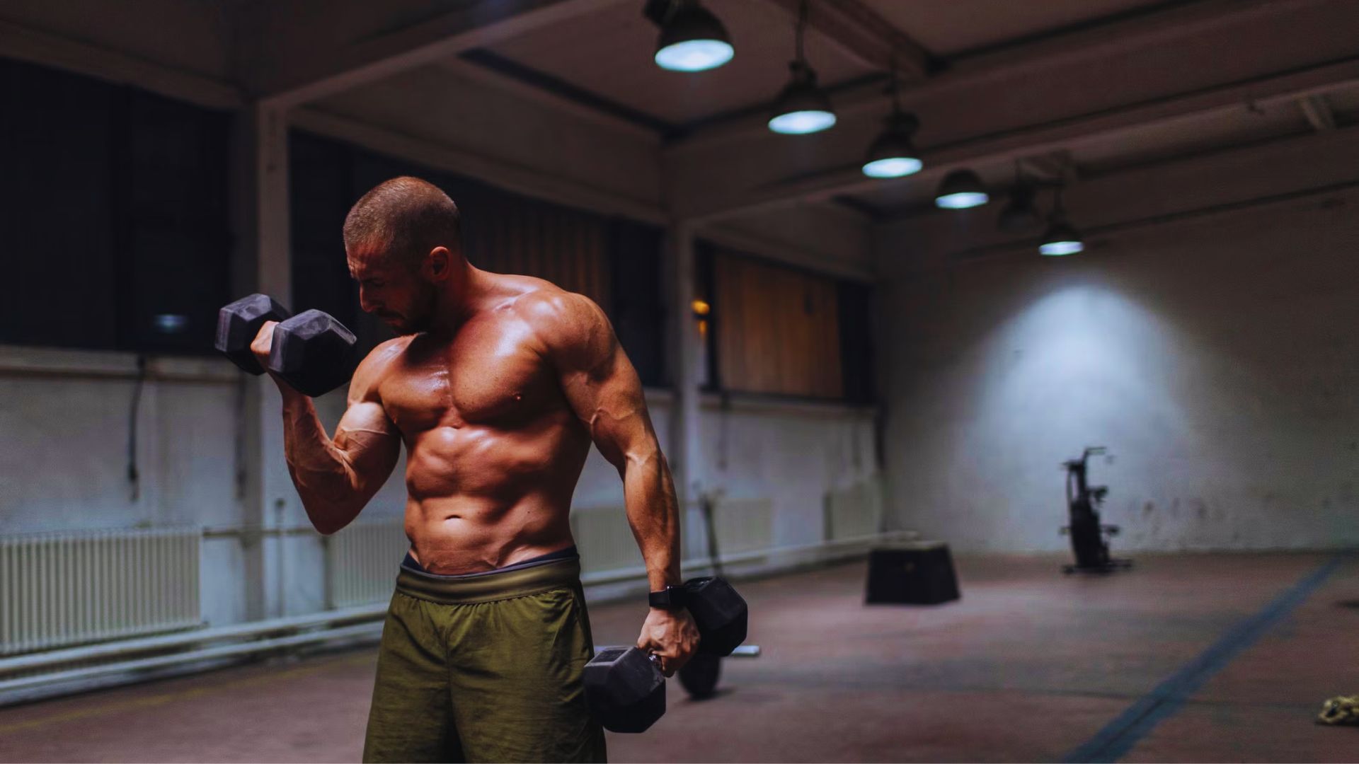 A man performing a reverse curl with weights in a gym, demonstrating common mistakes to avoid during the exercise.