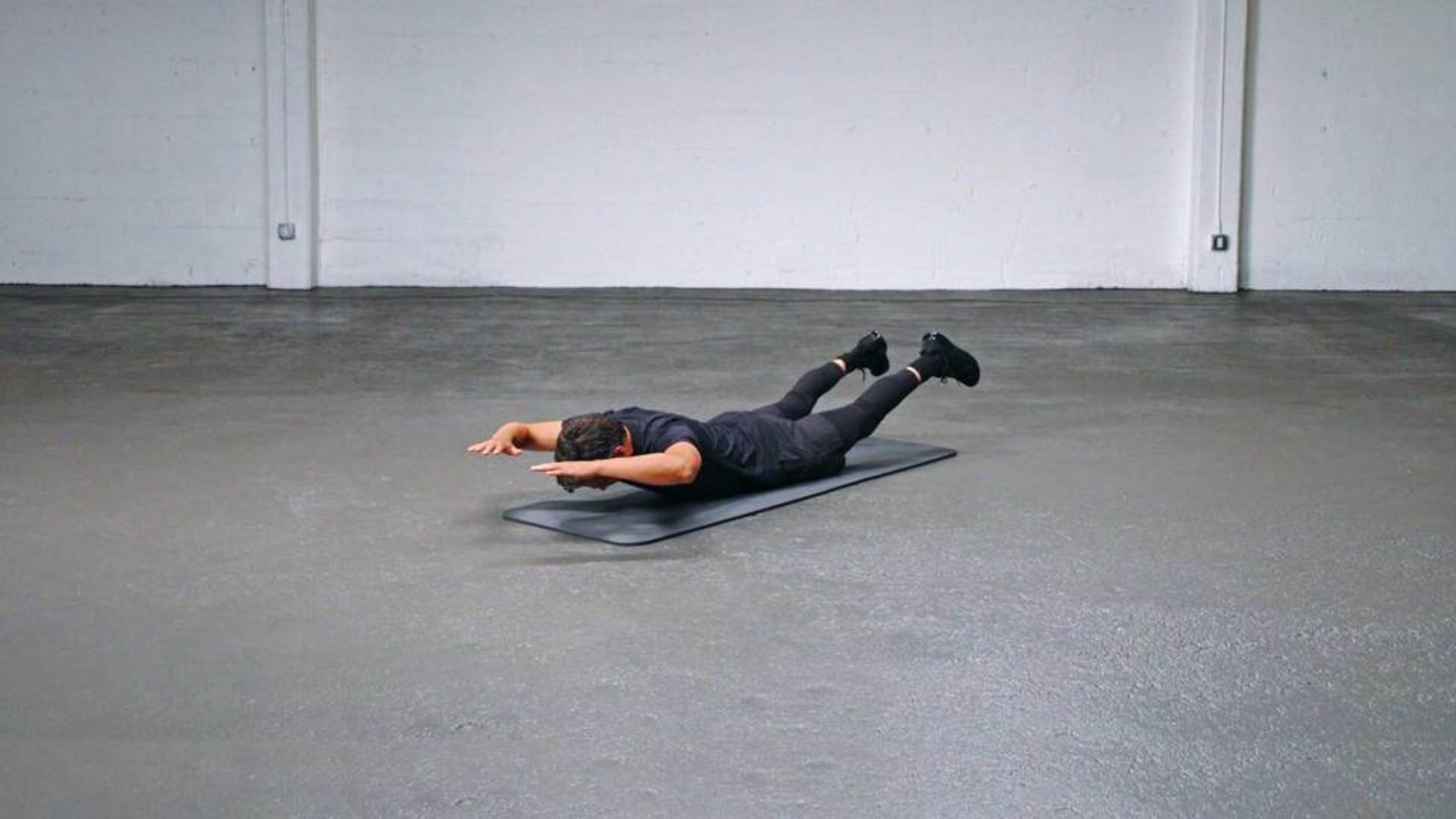 A man reclines on a mat on the floor, suggesting a moment of rest or relaxation in a comfortable environment.