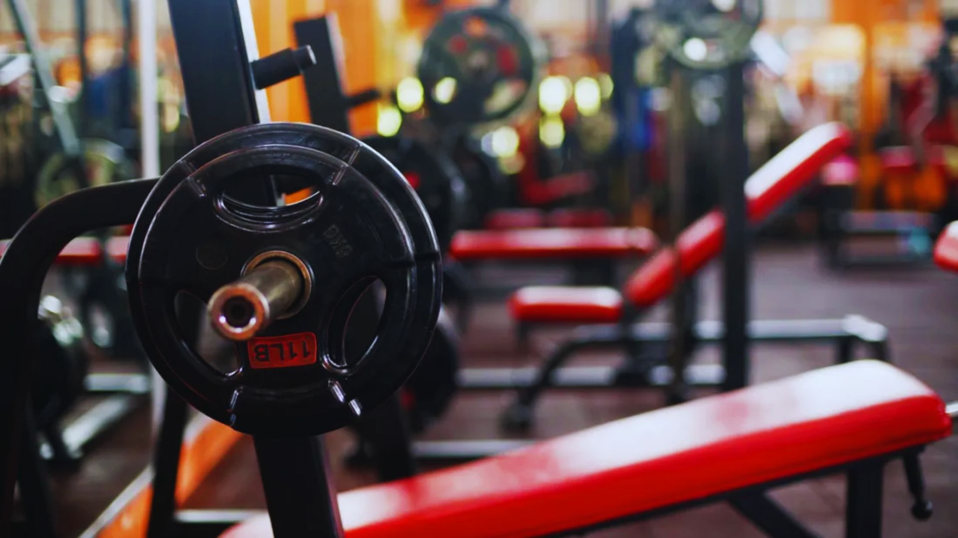 A gym interior featuring red and black benches arranged for workout sessions.