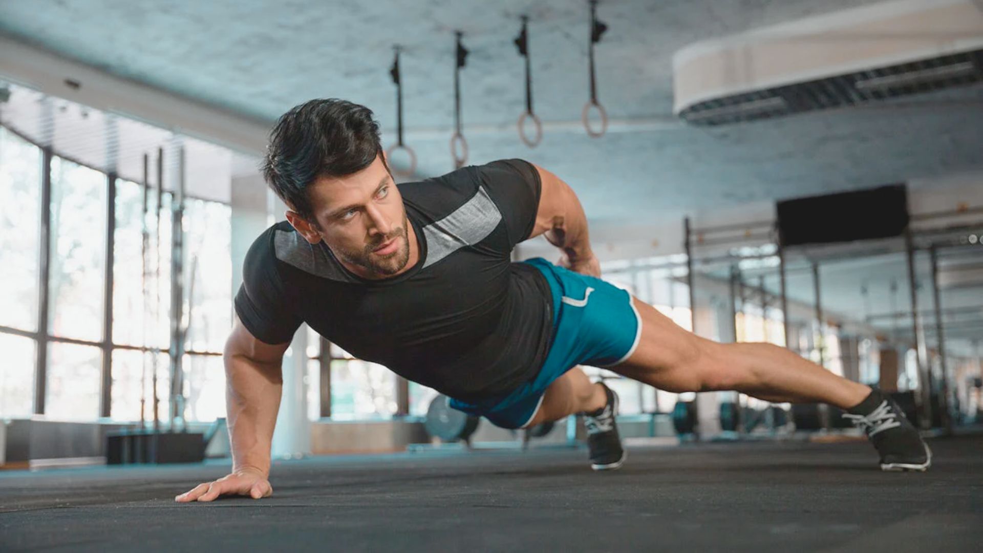A man performing push-ups on a gym floor, focusing on his form and strength training.