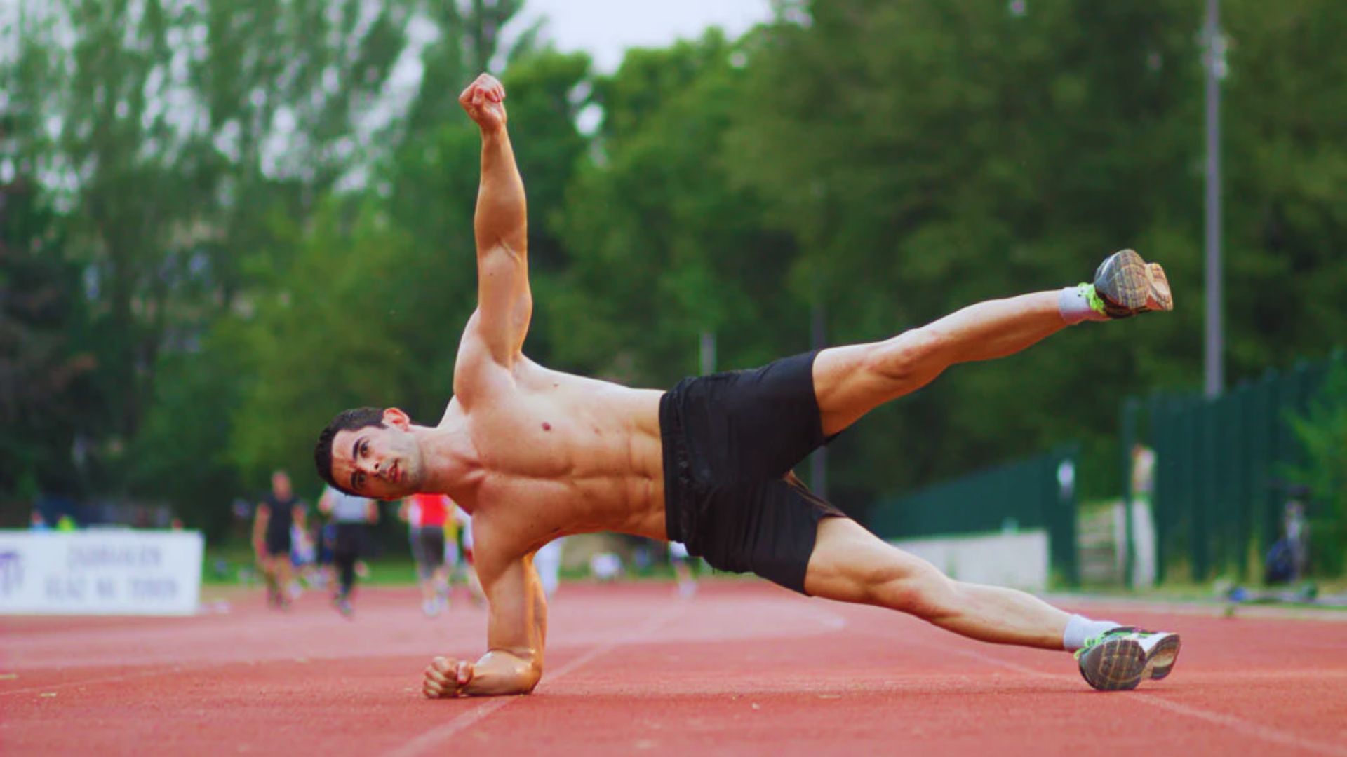 An athlete performs hip abduction exercises alongside compound movements, showcasing strength training techniques.