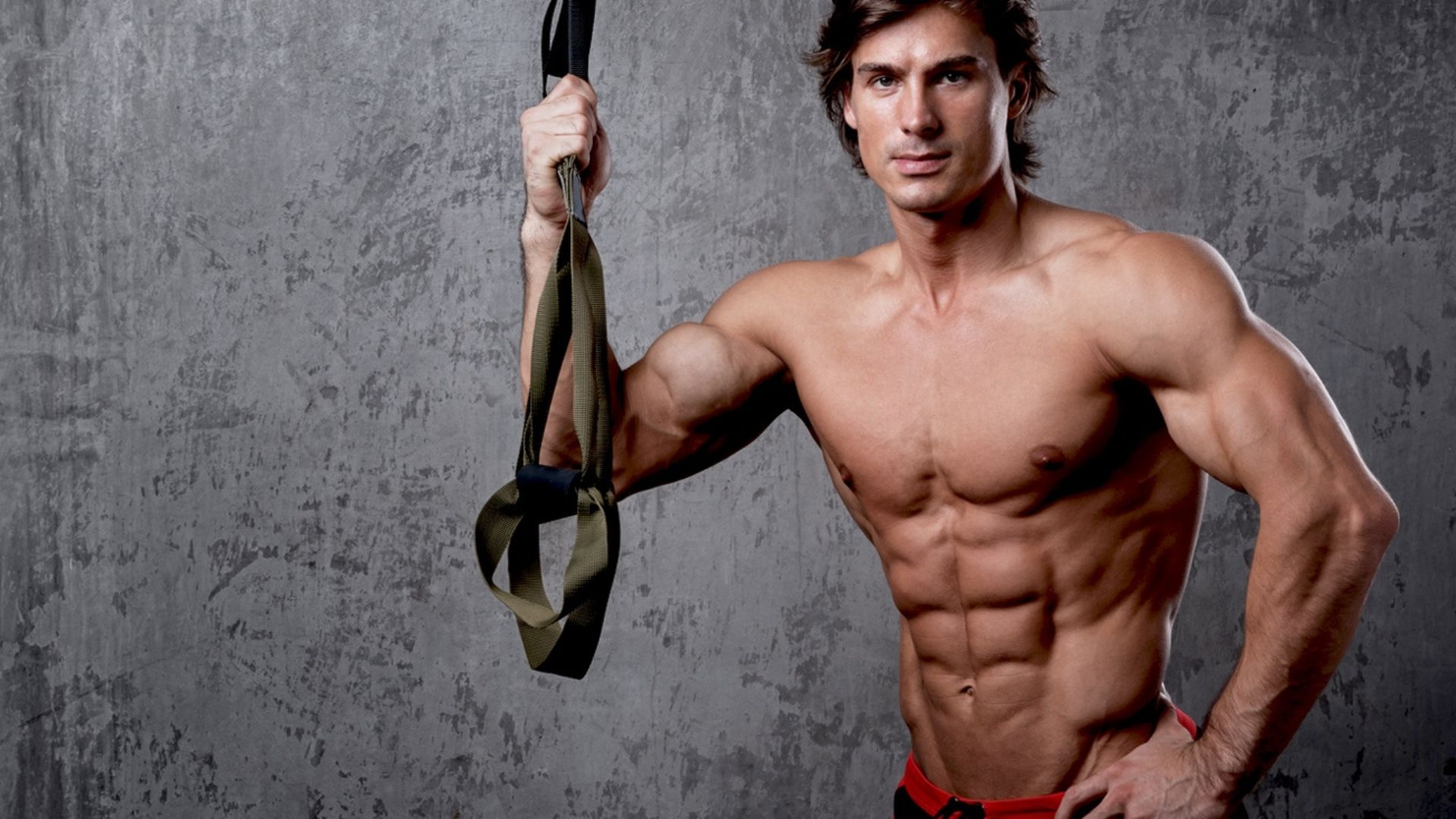 2. A muscular, shirtless man holds a thick rope, demonstrating physical prowess in a dynamic pose.