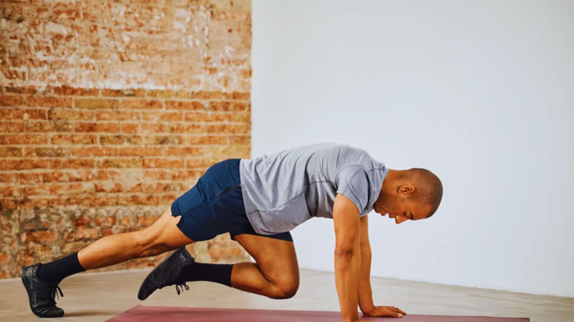 A man performing a push-up on a fitness mat, focusing on strength training and exercise form.