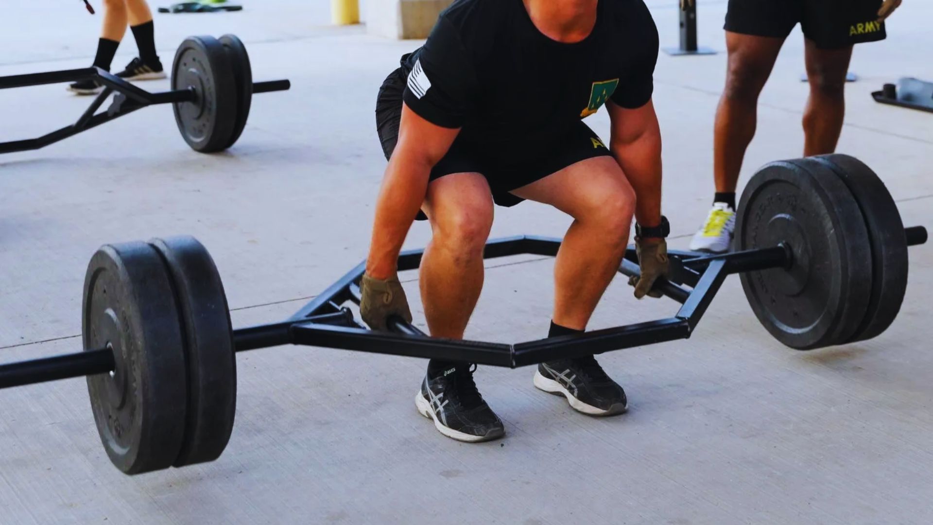 A man squats with a barbell on his shoulders in a gym, focusing on his form and strength training.