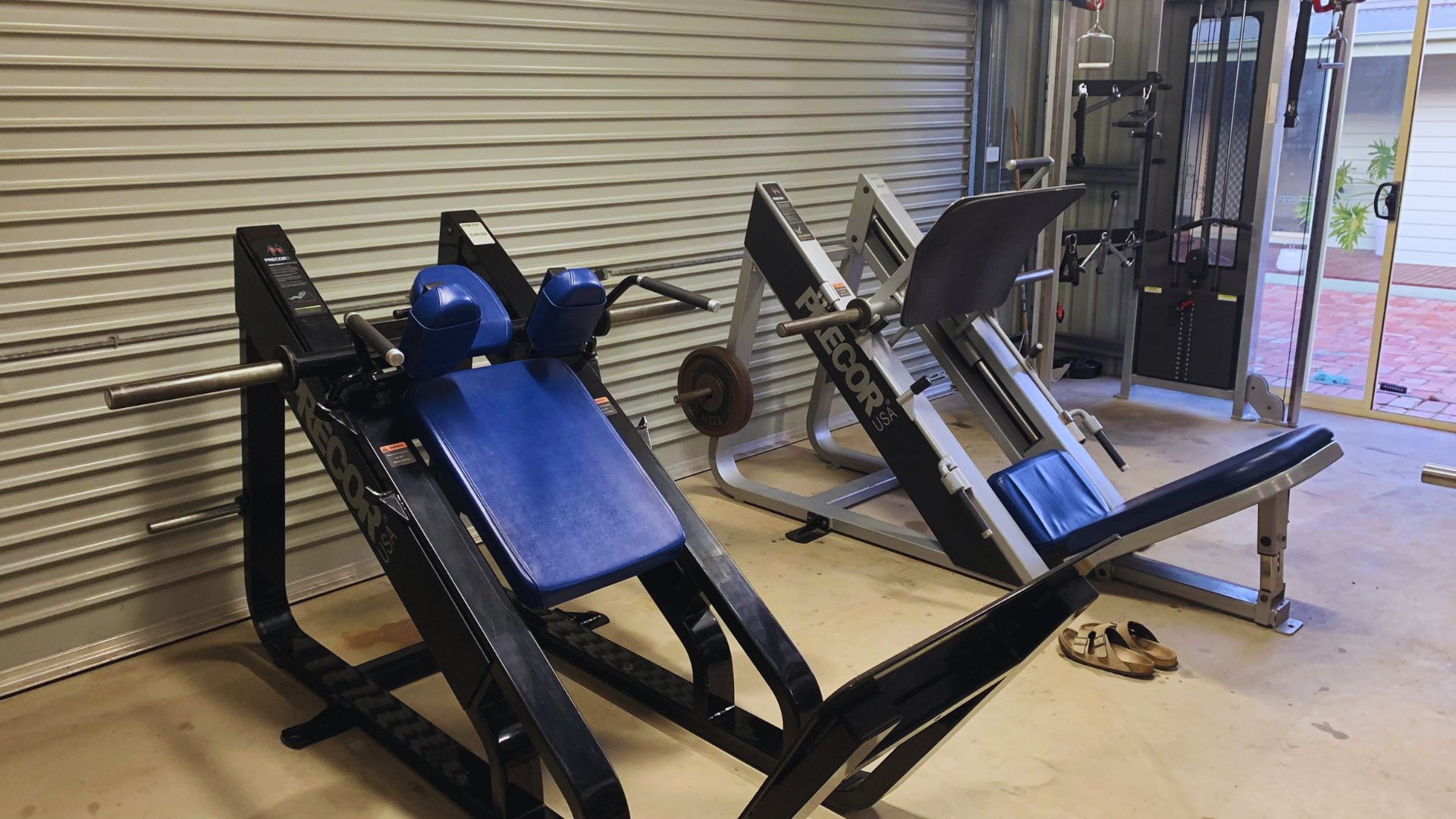 A gym interior featuring a weight bench and a squat rack, designed for strength training exercises.