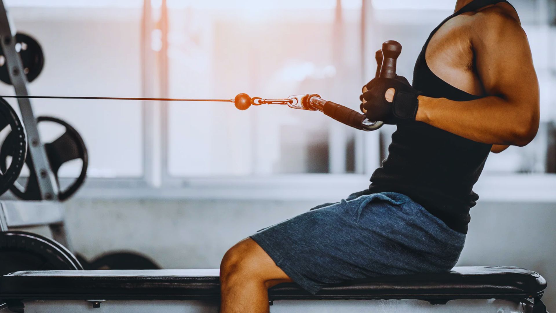 A man exercises with a rope in a gym, focusing on strength and endurance training.