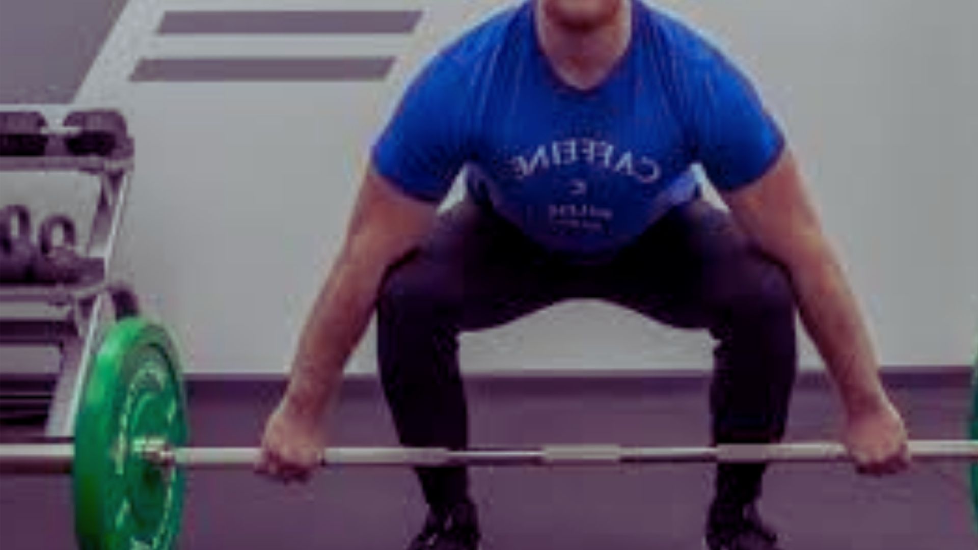 1. A man squats with a barbell on his shoulders in a gym, focusing on his form and strength training.