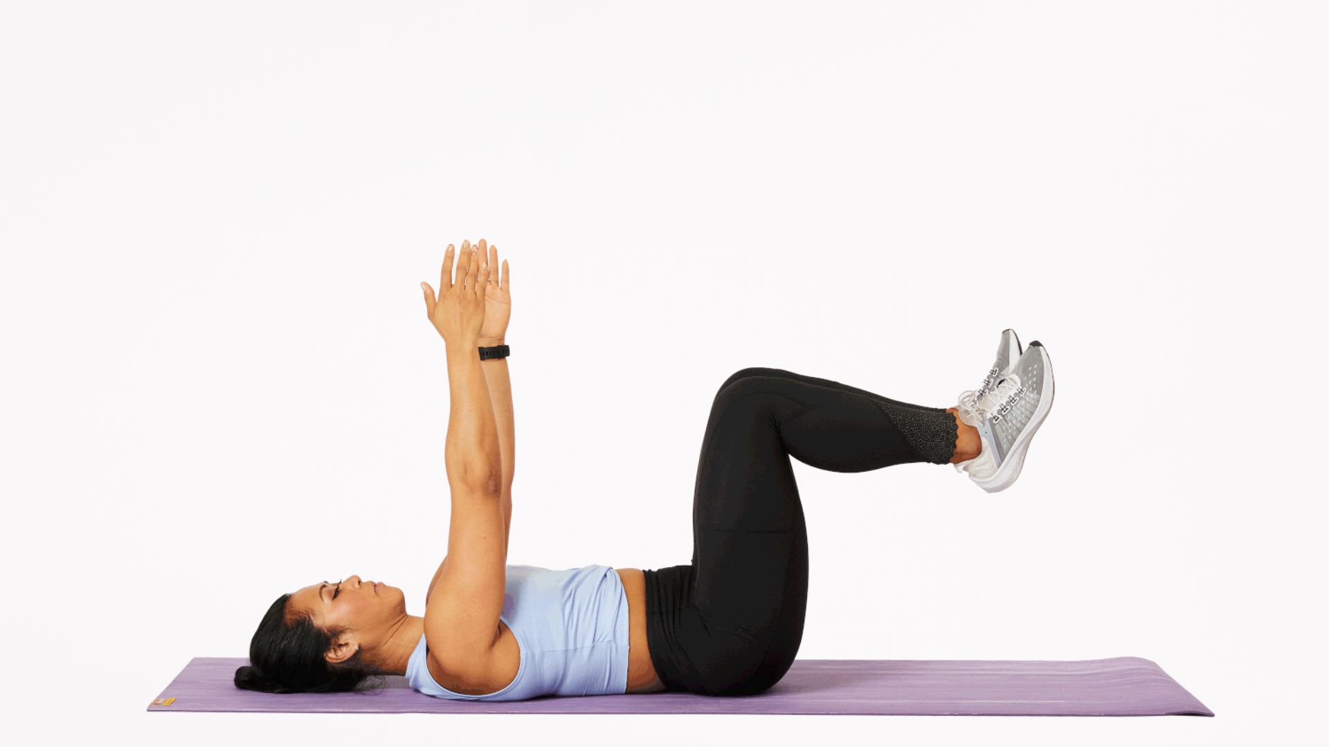 A woman is engaged in a side plank exercise on a purple mat, demonstrating core strength and stability.