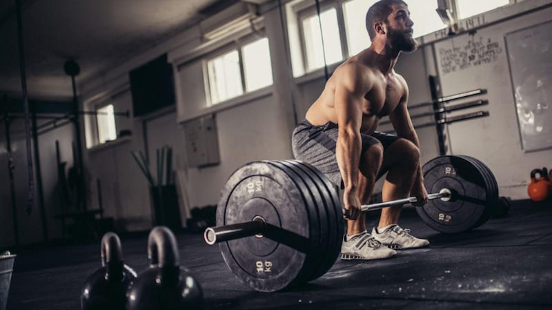 A man squats with a barbell, demonstrating strength training techniques for back off sets.