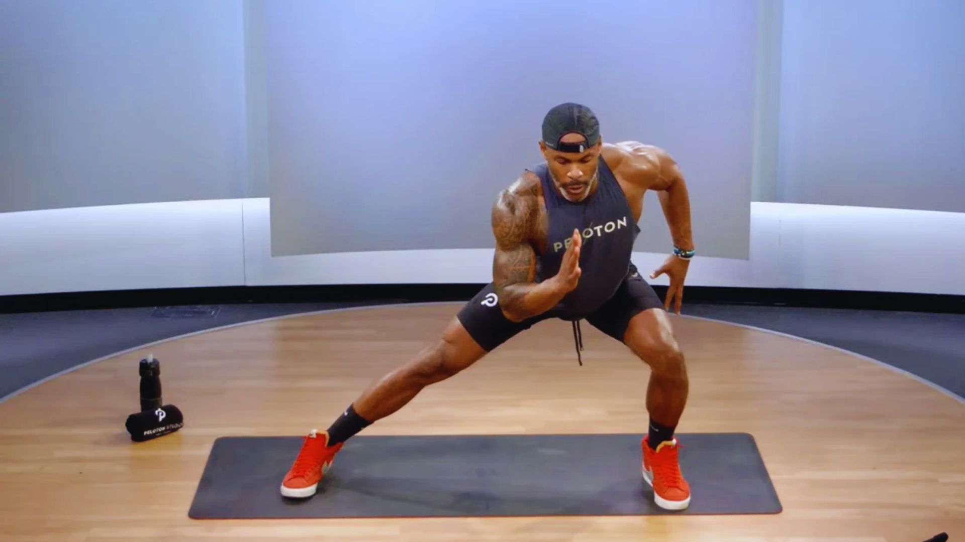 A man performing a squat on a fitness mat, focusing on his form and balance during the exercise.