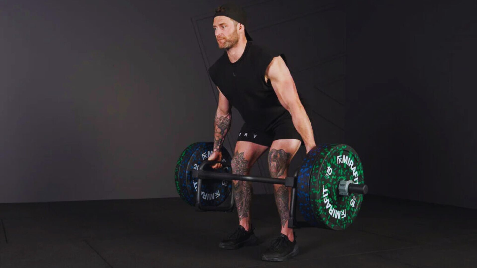 A man engages in a trap bar squat, lifting a barbell, demonstrating fitness and strength training.