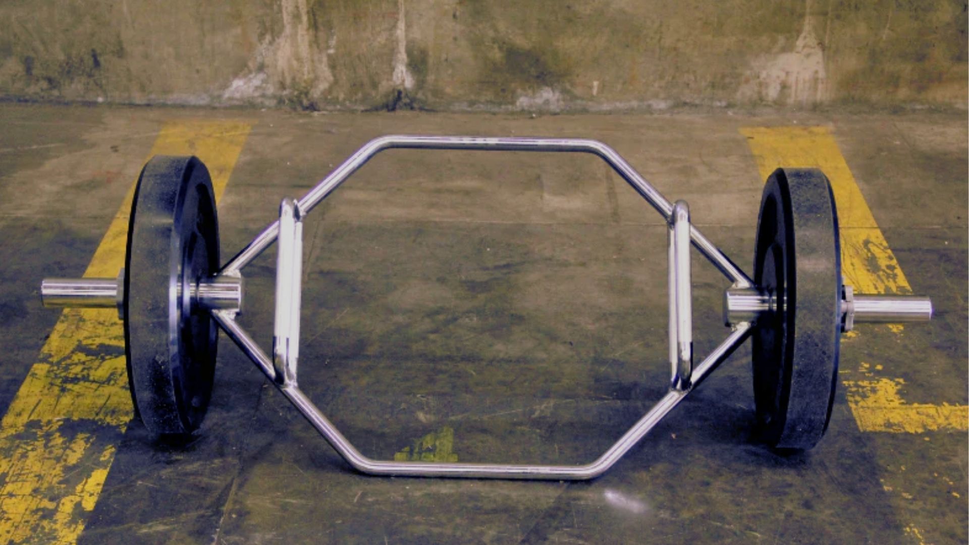 A Classic Standard Hex Bar with two wheels resting on the ground, ready for weightlifting exercises.