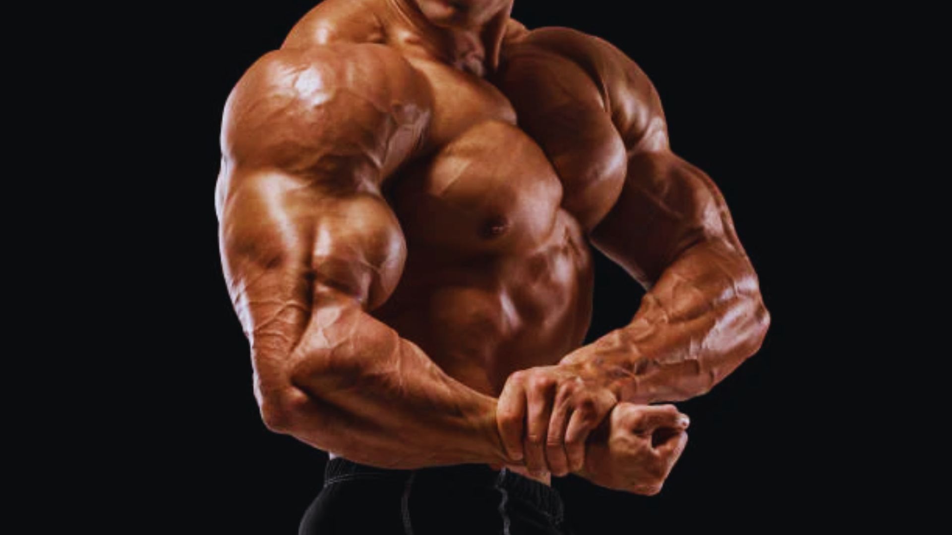 A muscular man flexing his biceps, showcasing strength and fitness in a gym setting.