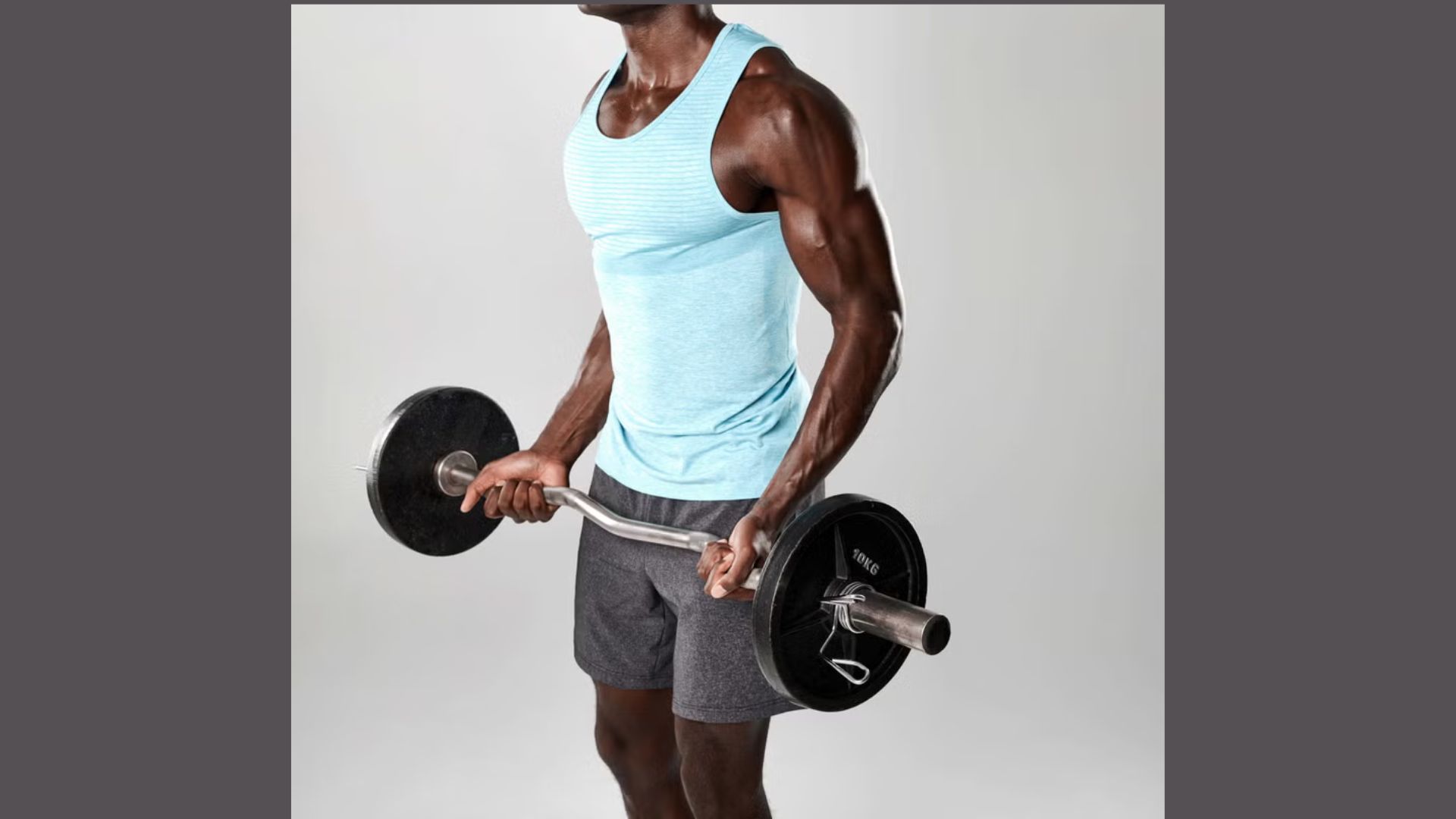 A man is engaged in strength training, lifting a dumbbell with determination in a gym.