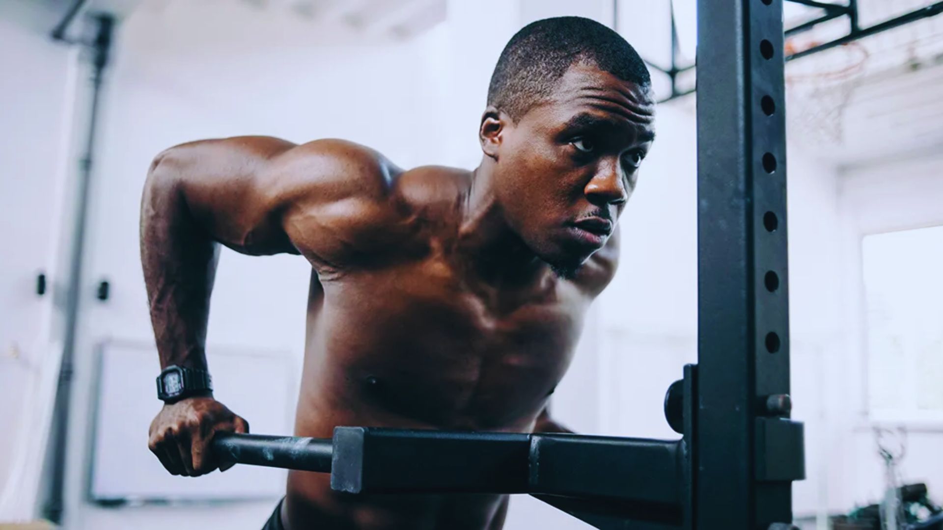 A man is engaged in pull-ups on a bar, demonstrating physical fitness and strength training.