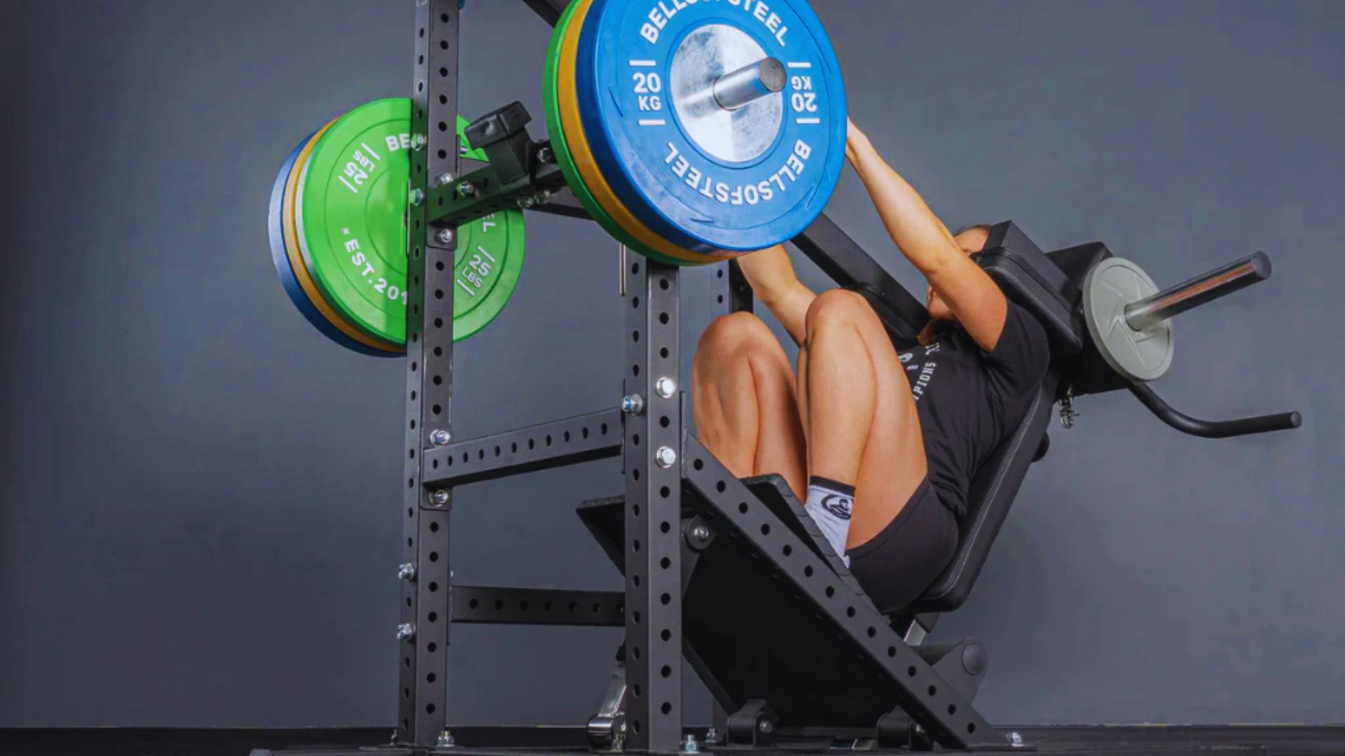 2. A man is positioned in a squat on a squat rack, demonstrating strength training in a fitness environment.