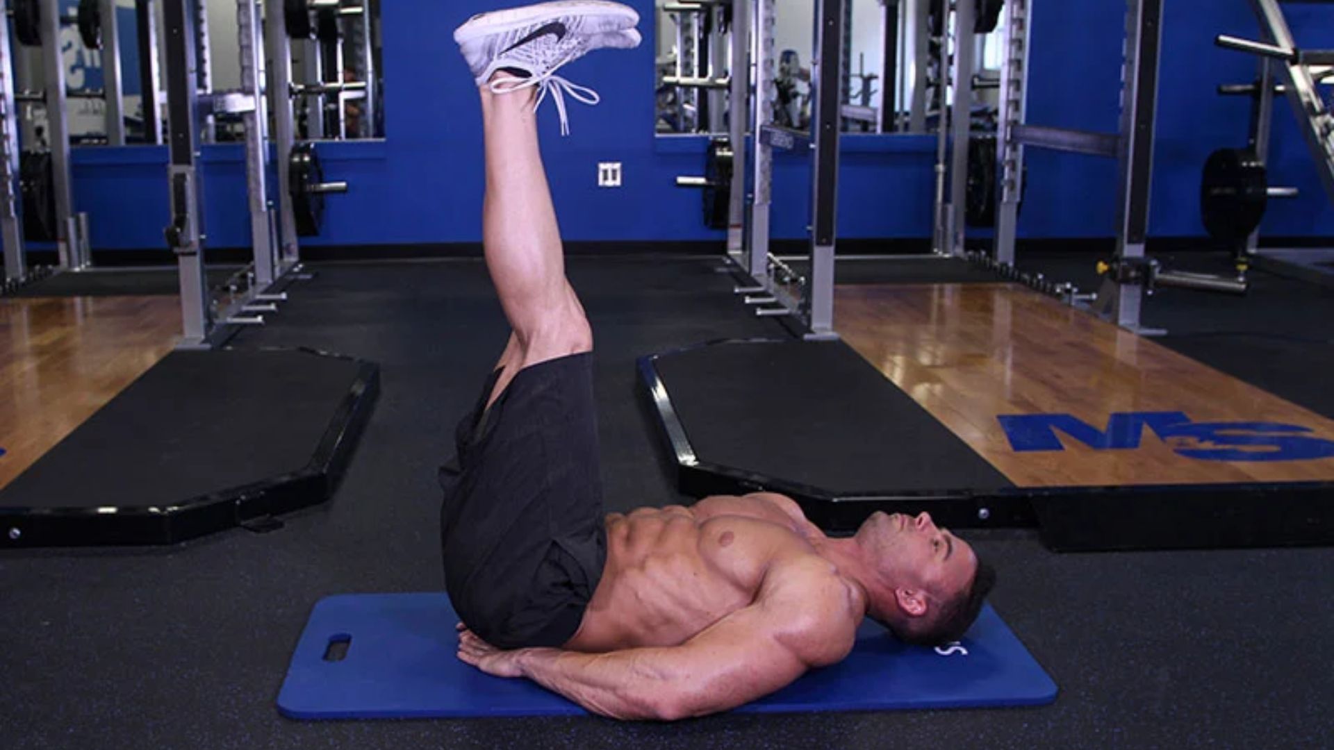 A man performing a leg extension exercise on a mat, focusing on strengthening his quadriceps.