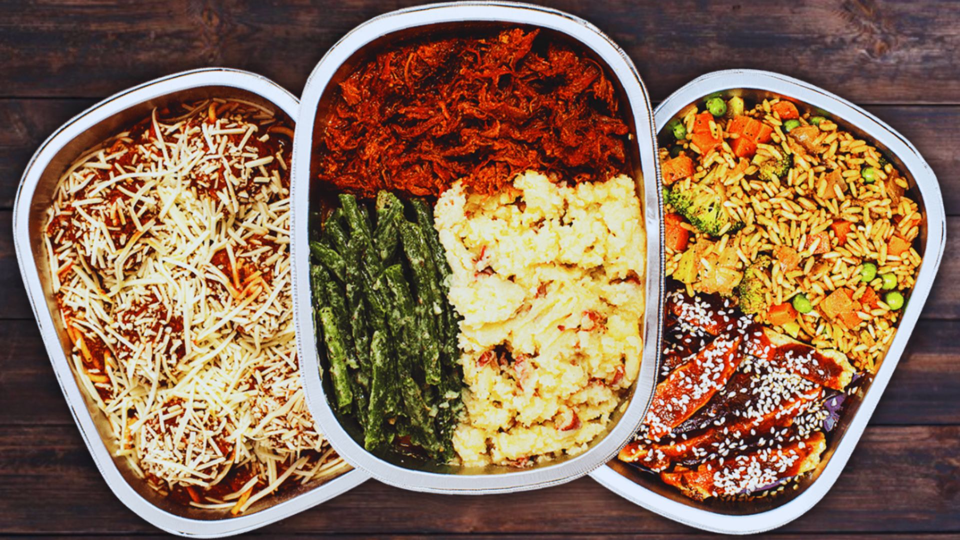 Three metal trays displaying an assortment of food items, ready for presentation or serving.