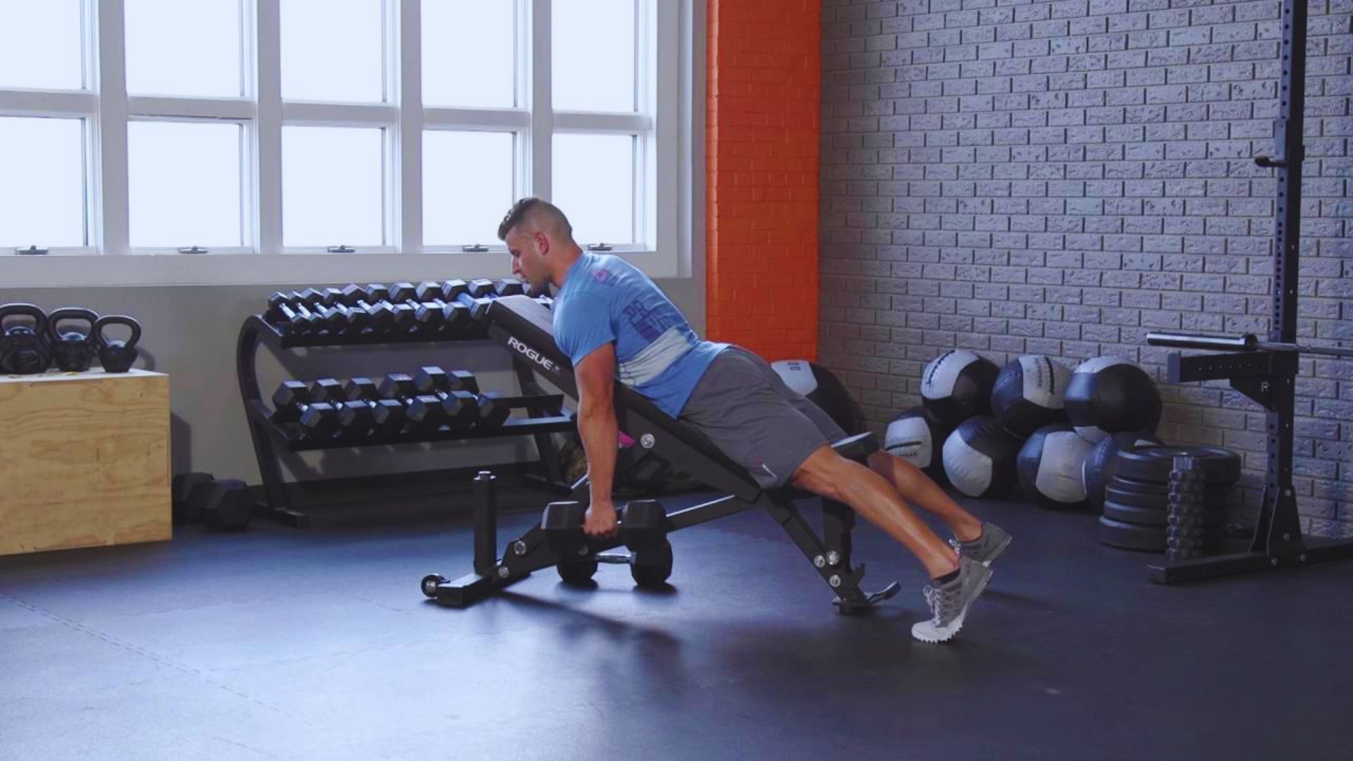 A man performs a push-up on a bench, demonstrating strength and fitness in an outdoor setting.
