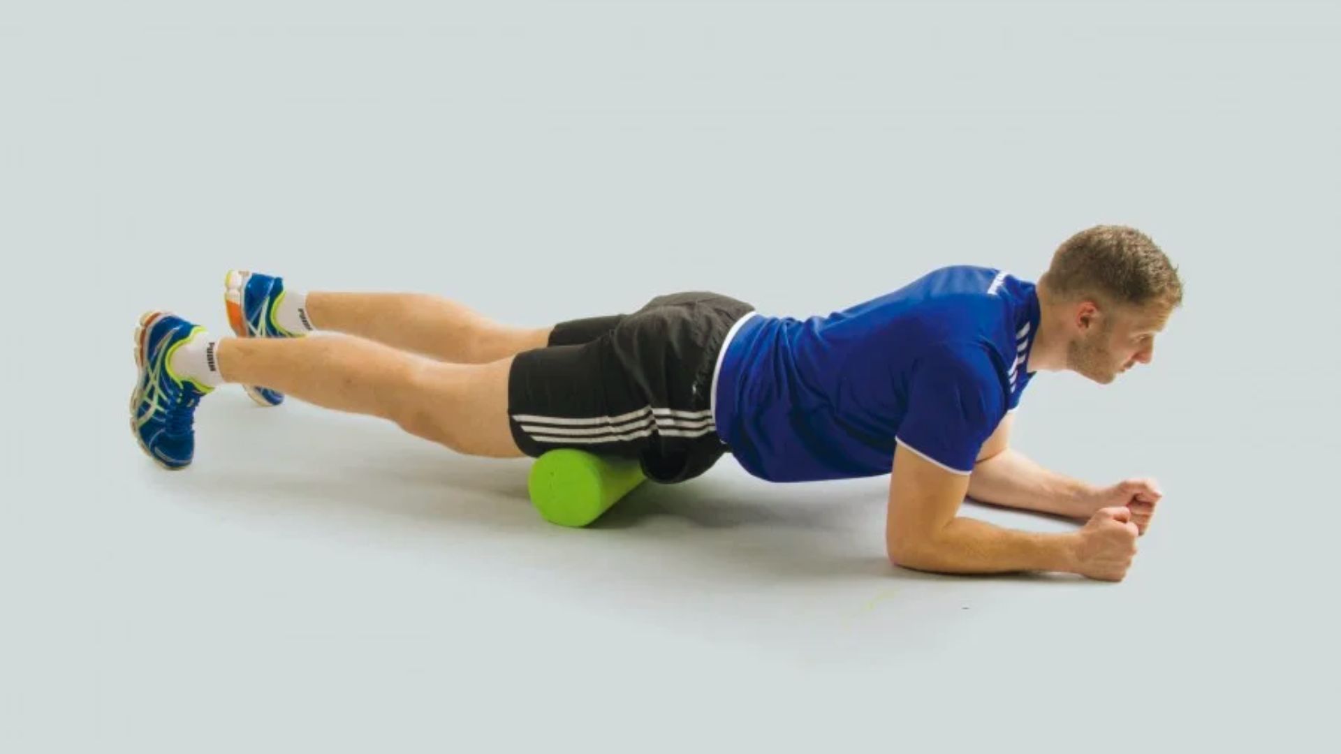 A man performs a back stretch using a foam roller, enhancing flexibility and relieving tension in his muscles.