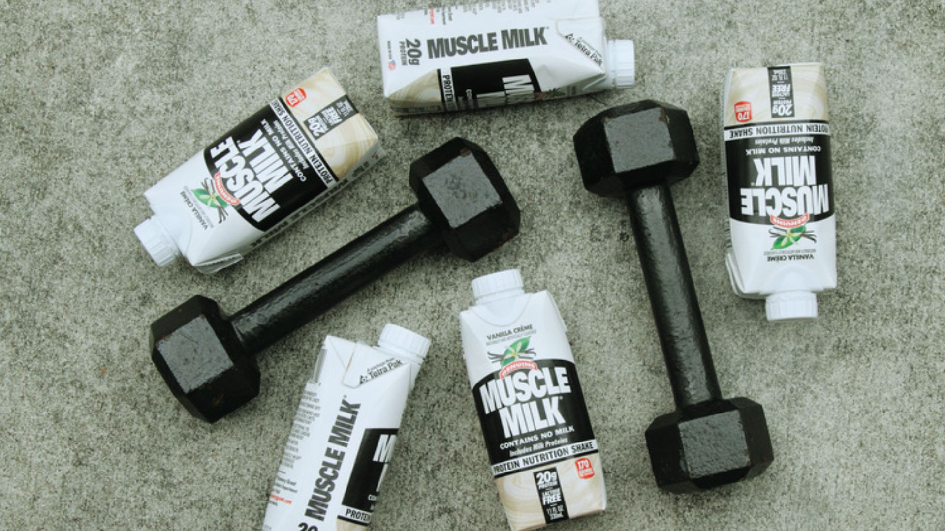 A collection of four distinct types of dumbbells arranged together on a surface.
