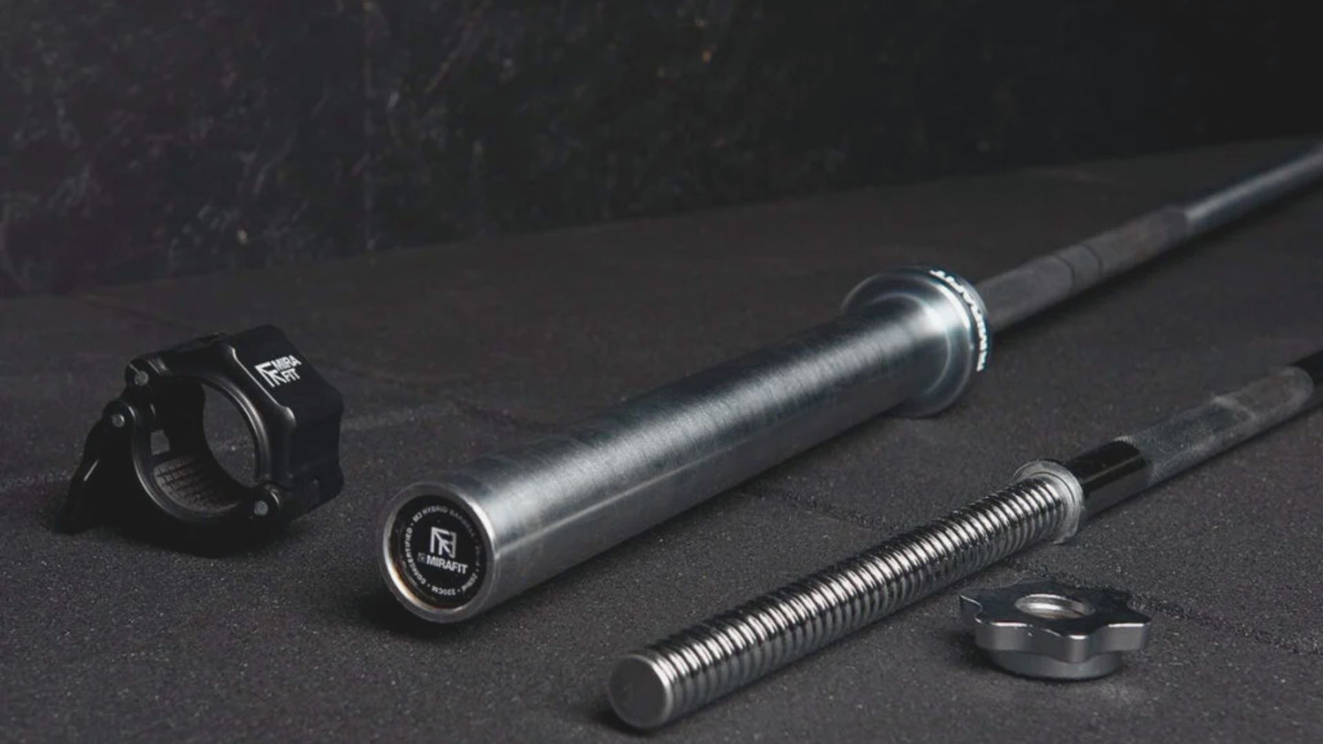 A barbell and a screw resting on a smooth black surface, highlighting their metallic textures and shapes.