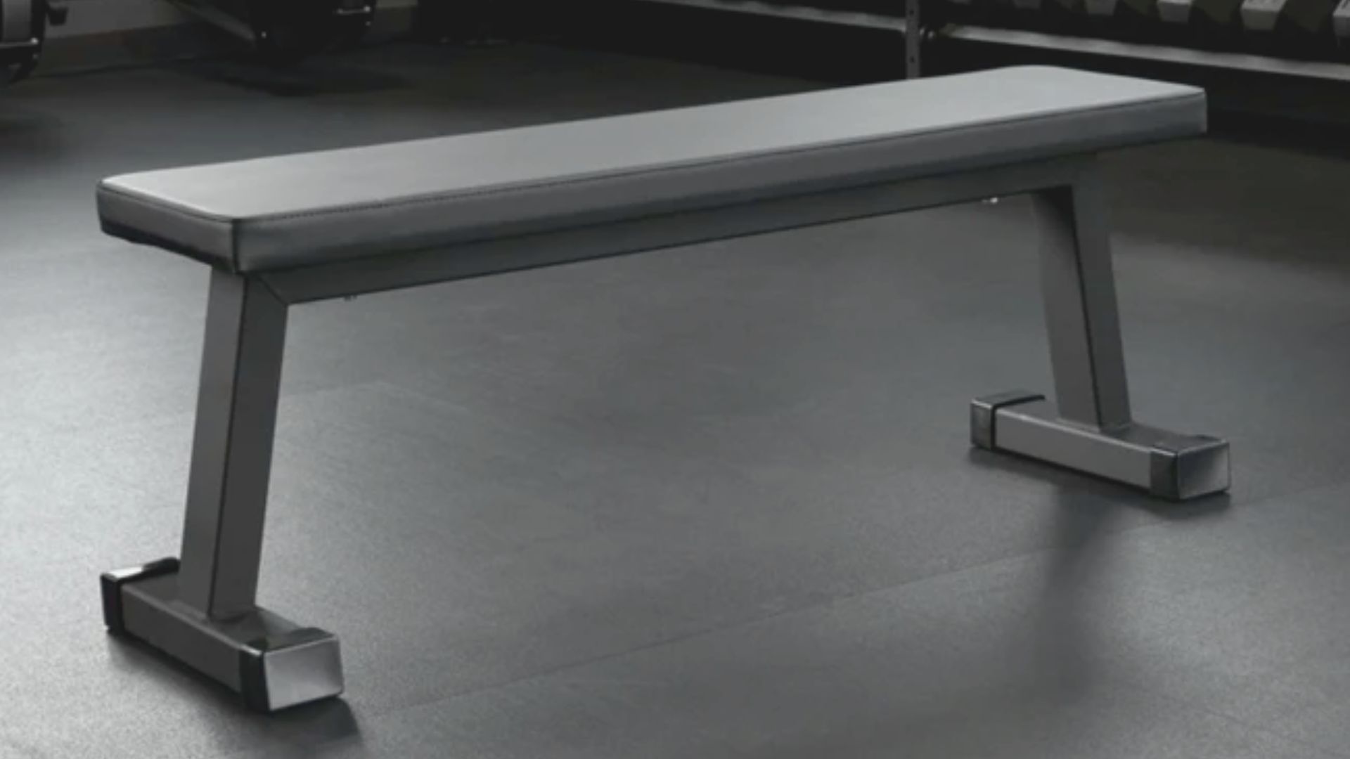 A gym bench featuring a black seat and a black bar, designed for strength training exercises.