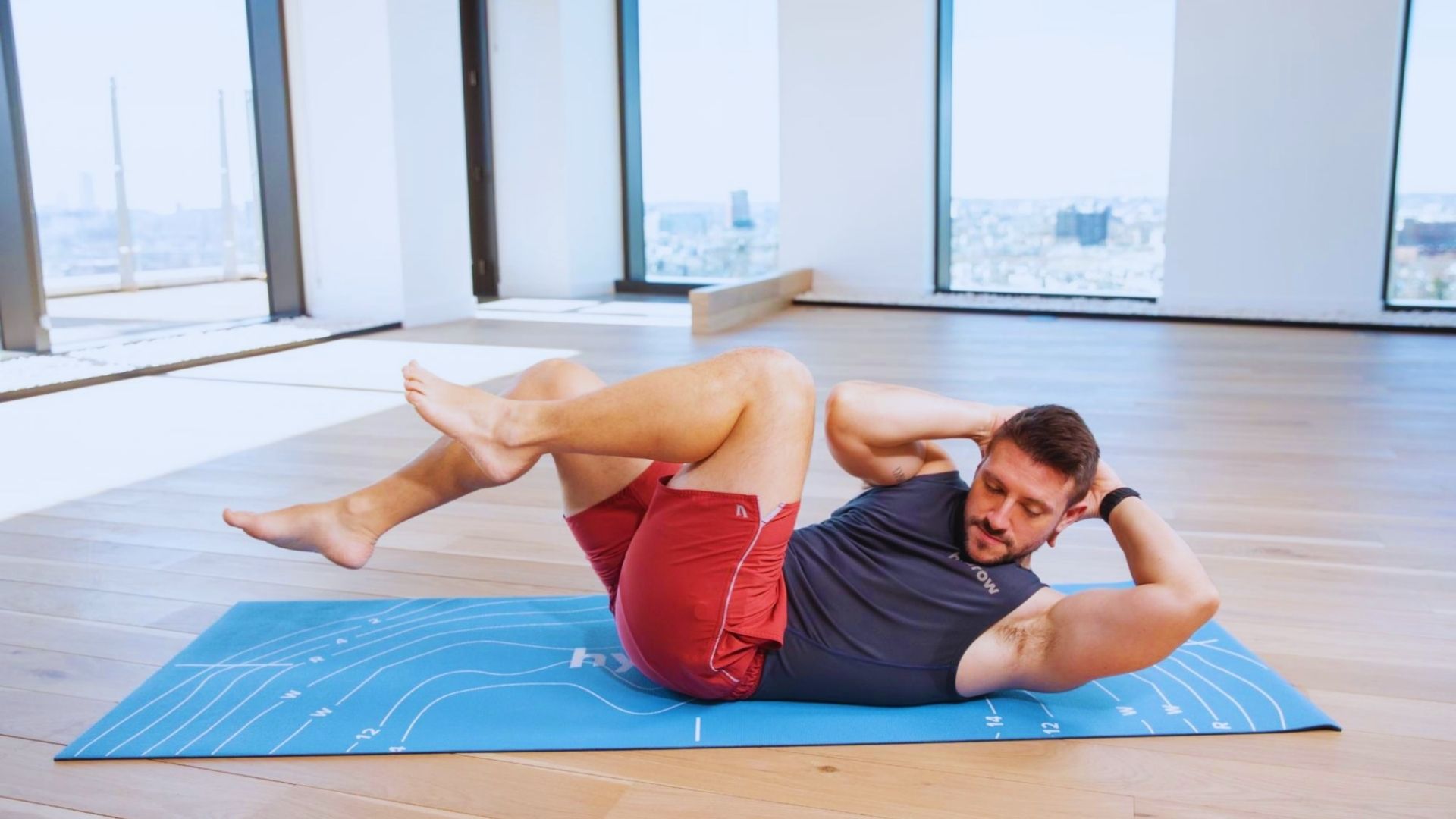 A woman performs a sit-up on a fitness mat, focusing on her core strength and exercise routine.