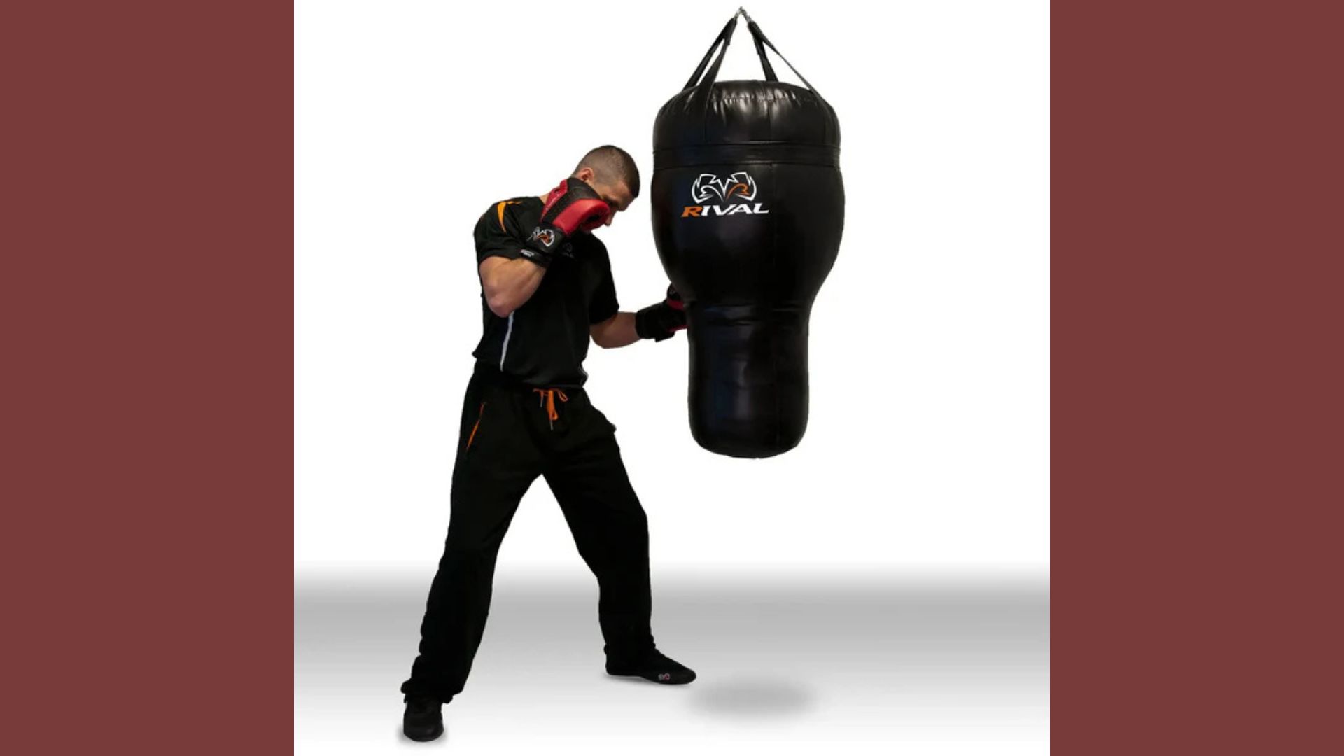 A man stands holding a punching bag in front of him, preparing for a workout or training session.