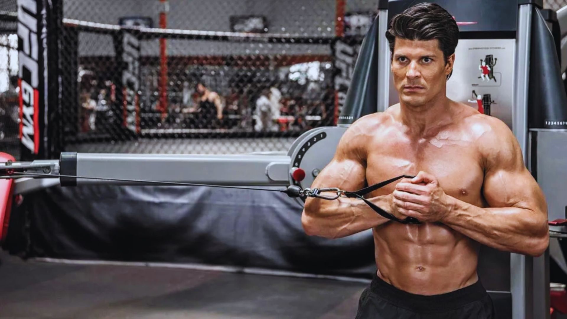 A man stands in front of a gym machine, preparing to begin his workout routine.