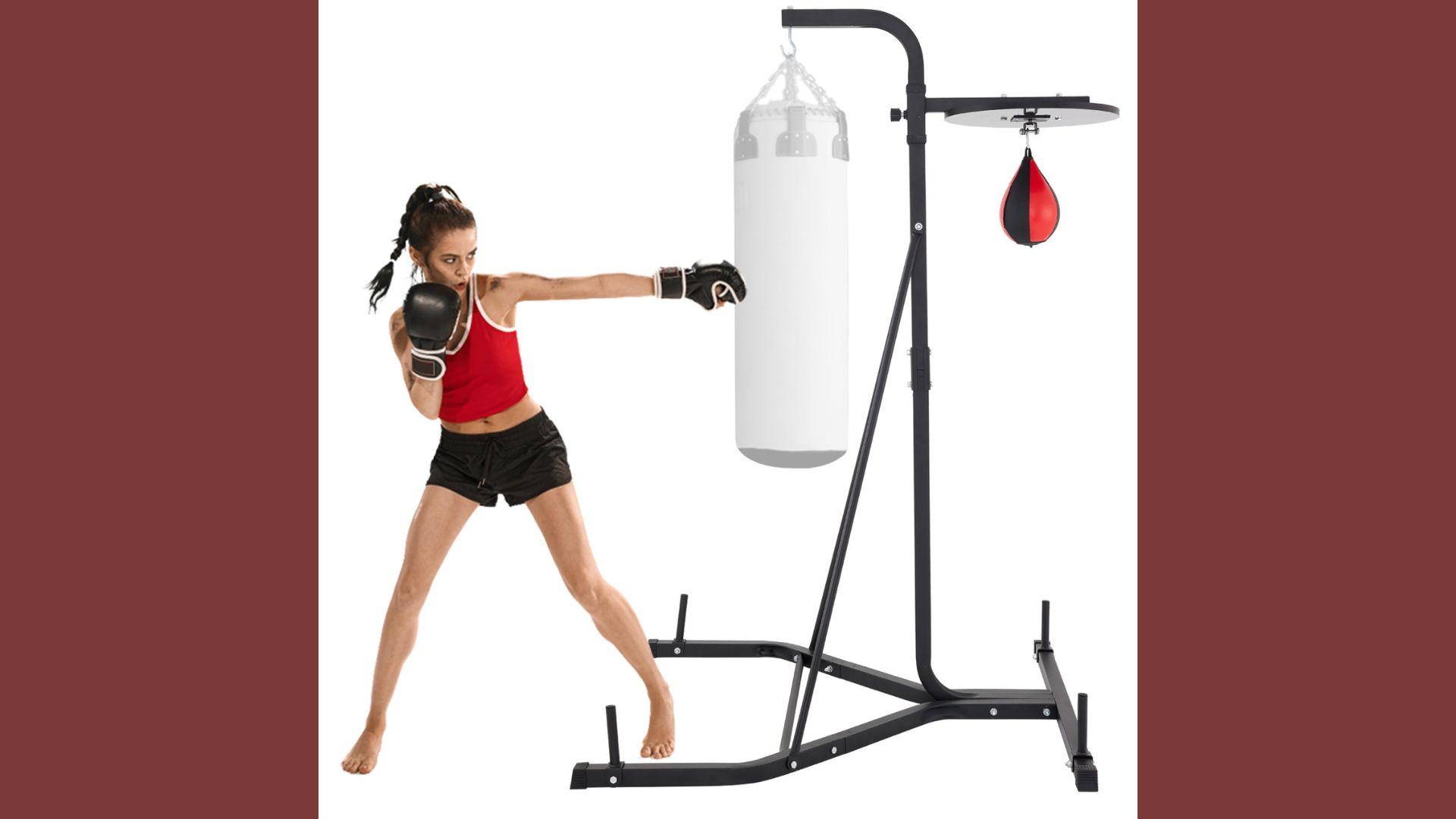 A woman practices boxing techniques while striking a punching bag in a gym setting.