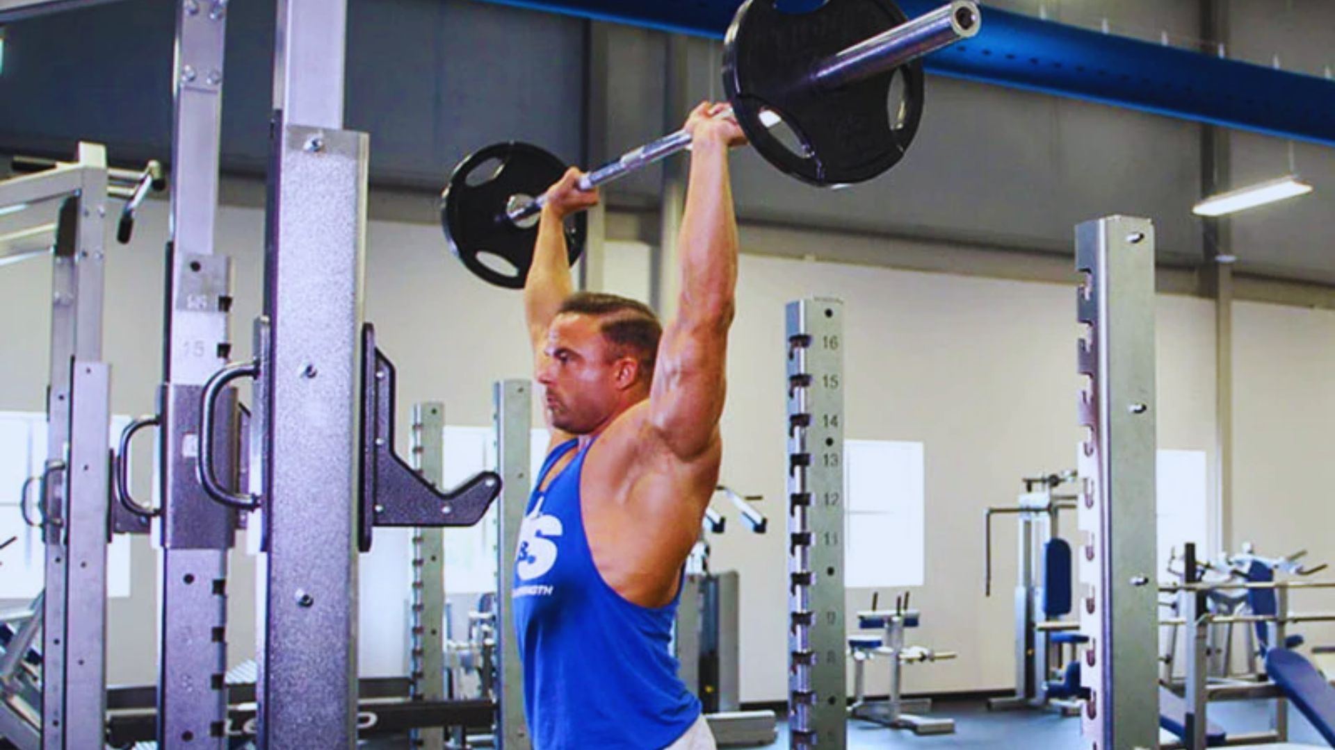 A man is engaged in a pull-up exercise at the gym, highlighting his fitness training and muscular effort.