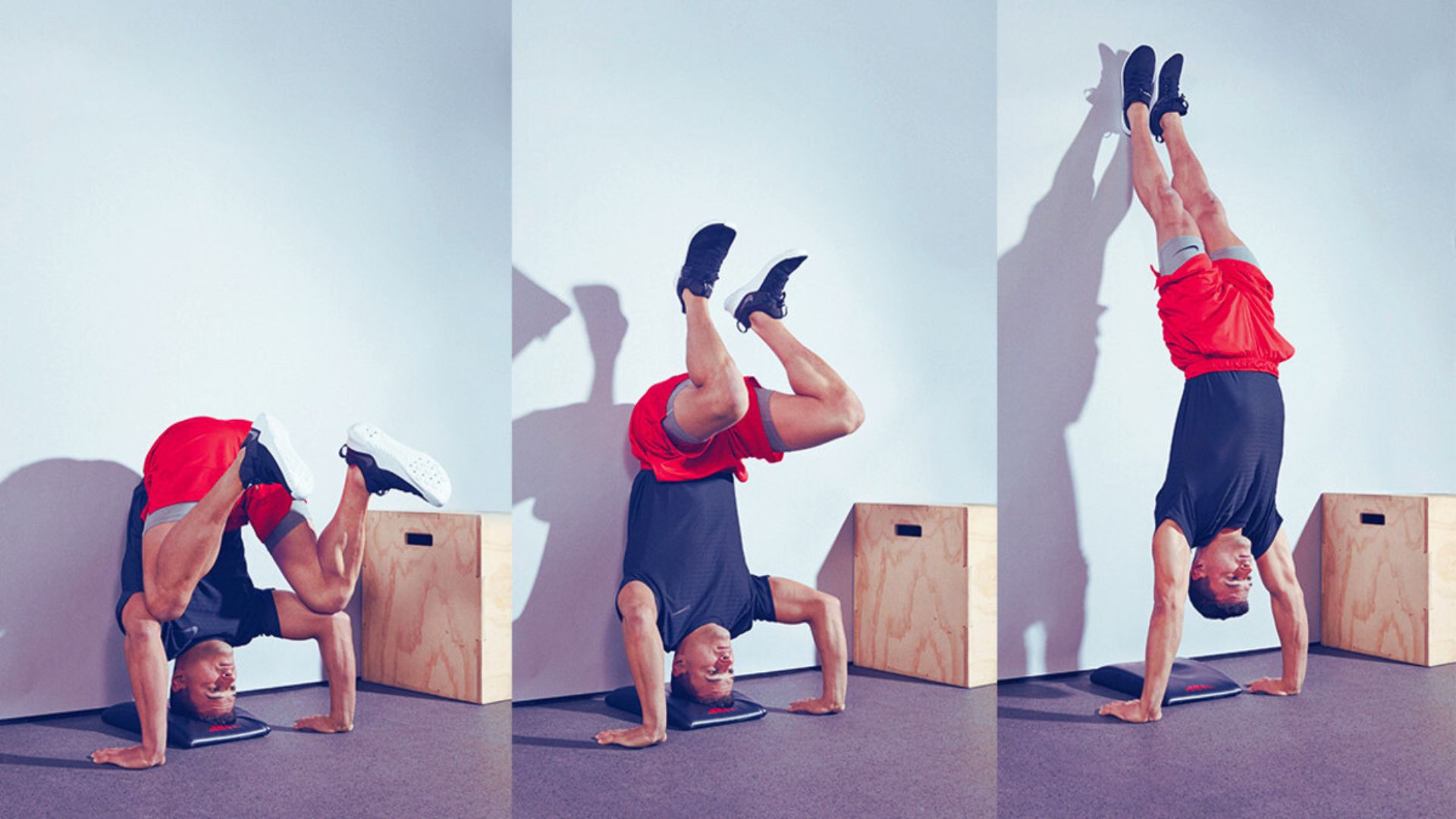 Man in a black shirt and red shorts performs a headstand against a wall, progressing from crouched to fully extended position. Wooden box nearby.