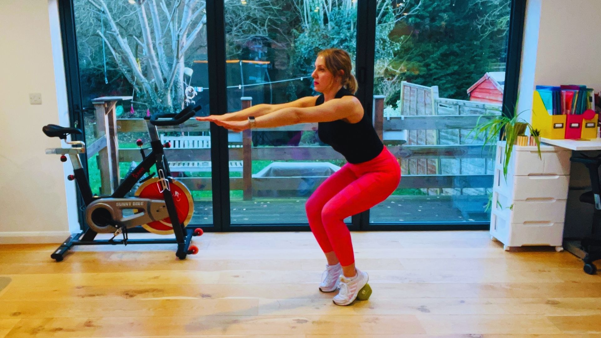 A woman performing squats in a gym, focusing on her form and strength training.