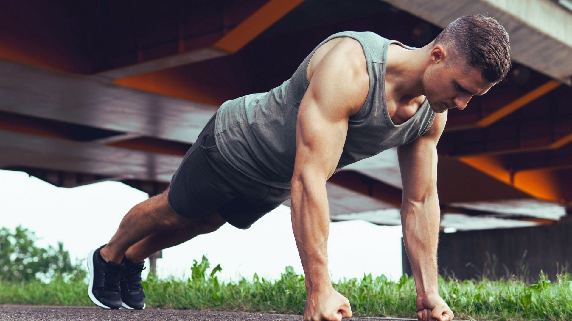 A man performs push-ups on a city street, showcasing his fitness routine in an urban environment.